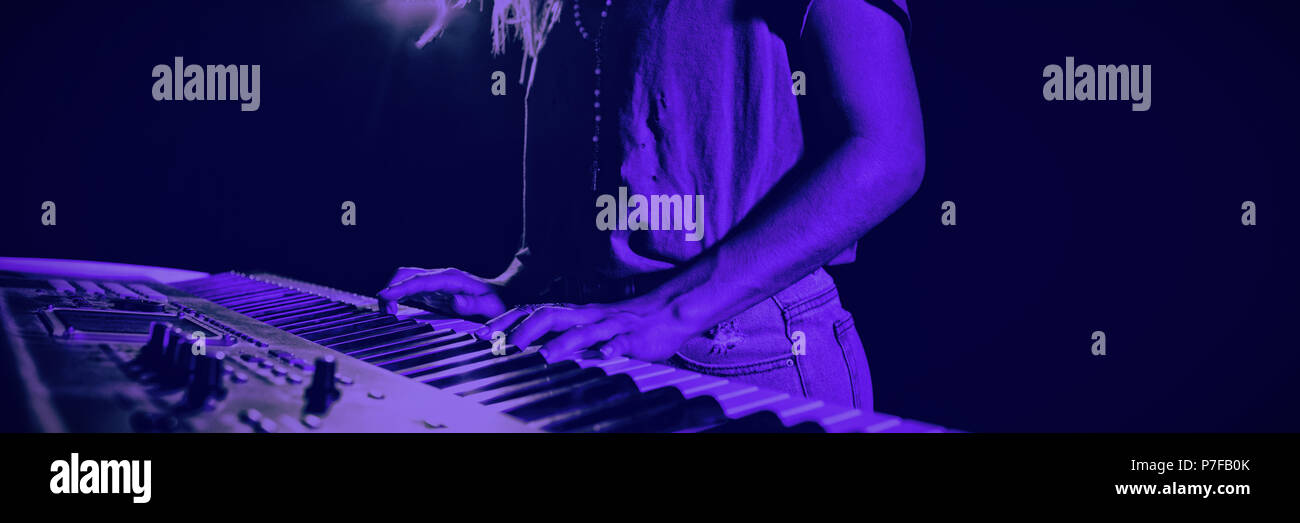 Mid section of female musician playing piano Stock Photo