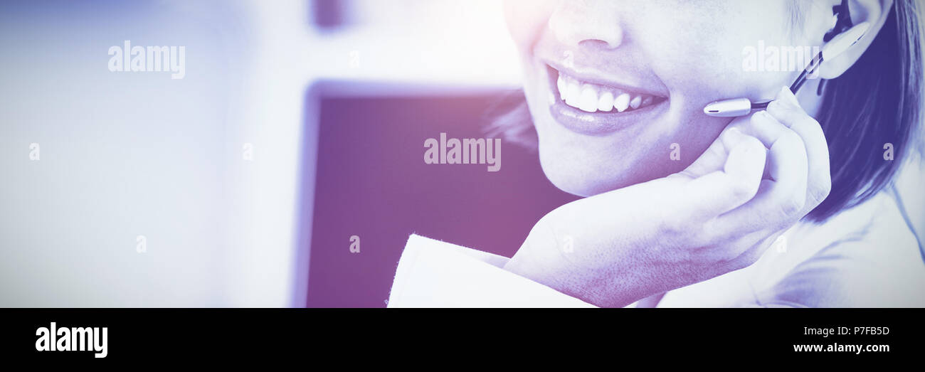 Cute businesswoman talking with clients in front of her computer Stock Photo