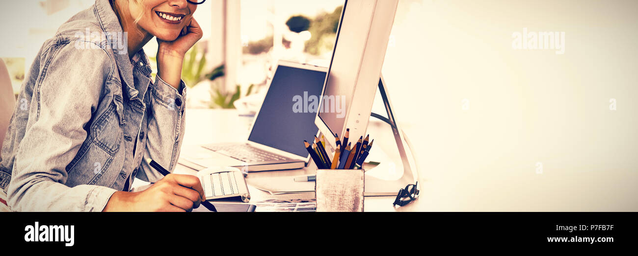 Blonde pretty designer looking at the camera using digitizer Stock Photo