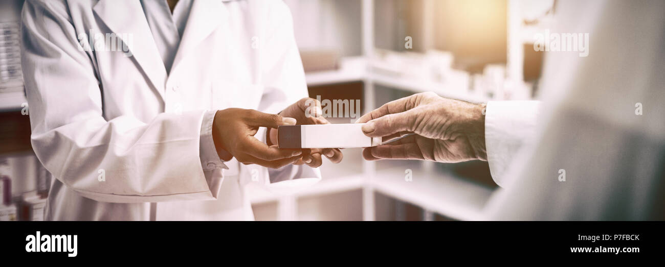 Cropped image of patient hand taking box from pharmacist Stock Photo