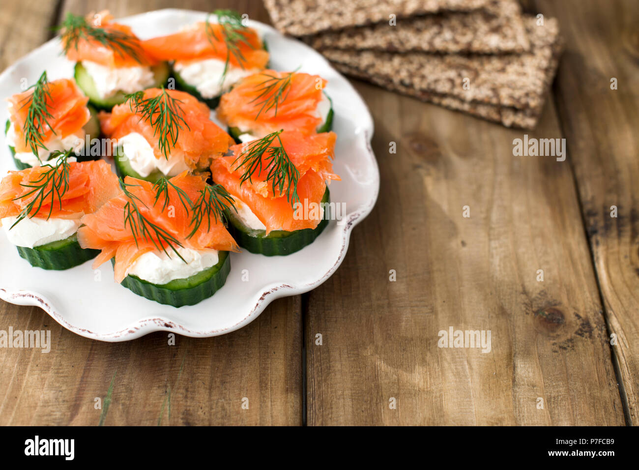 cucumber and salmon, small snacks on a plate. Copy space Stock Photo