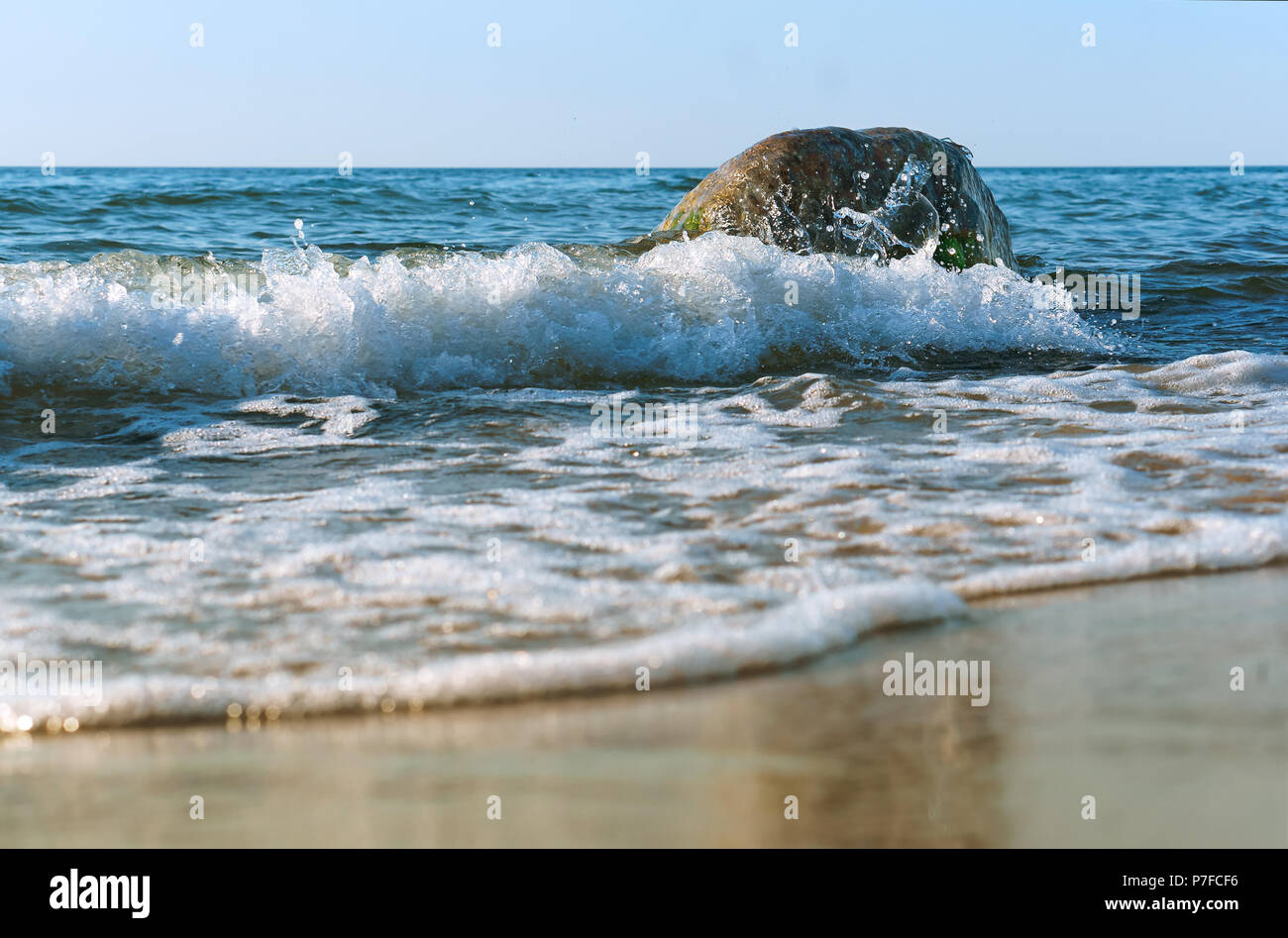 the sea wave hits the shore, the waves break on the coastal rocks Stock