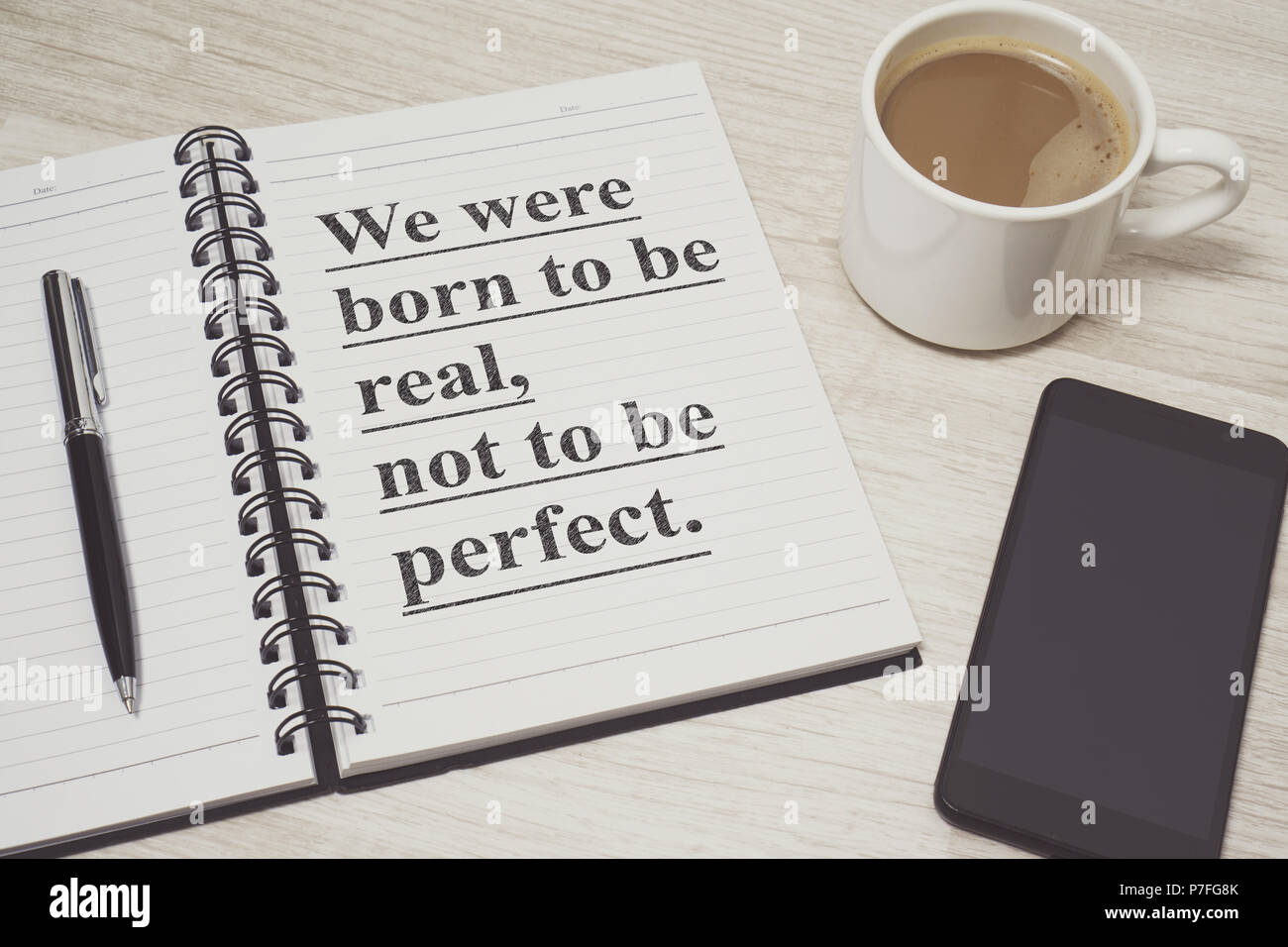 Notebook With Wisdom Quote With Coffee Cup And Cell Phone On Wood Desk Stock Photo Alamy