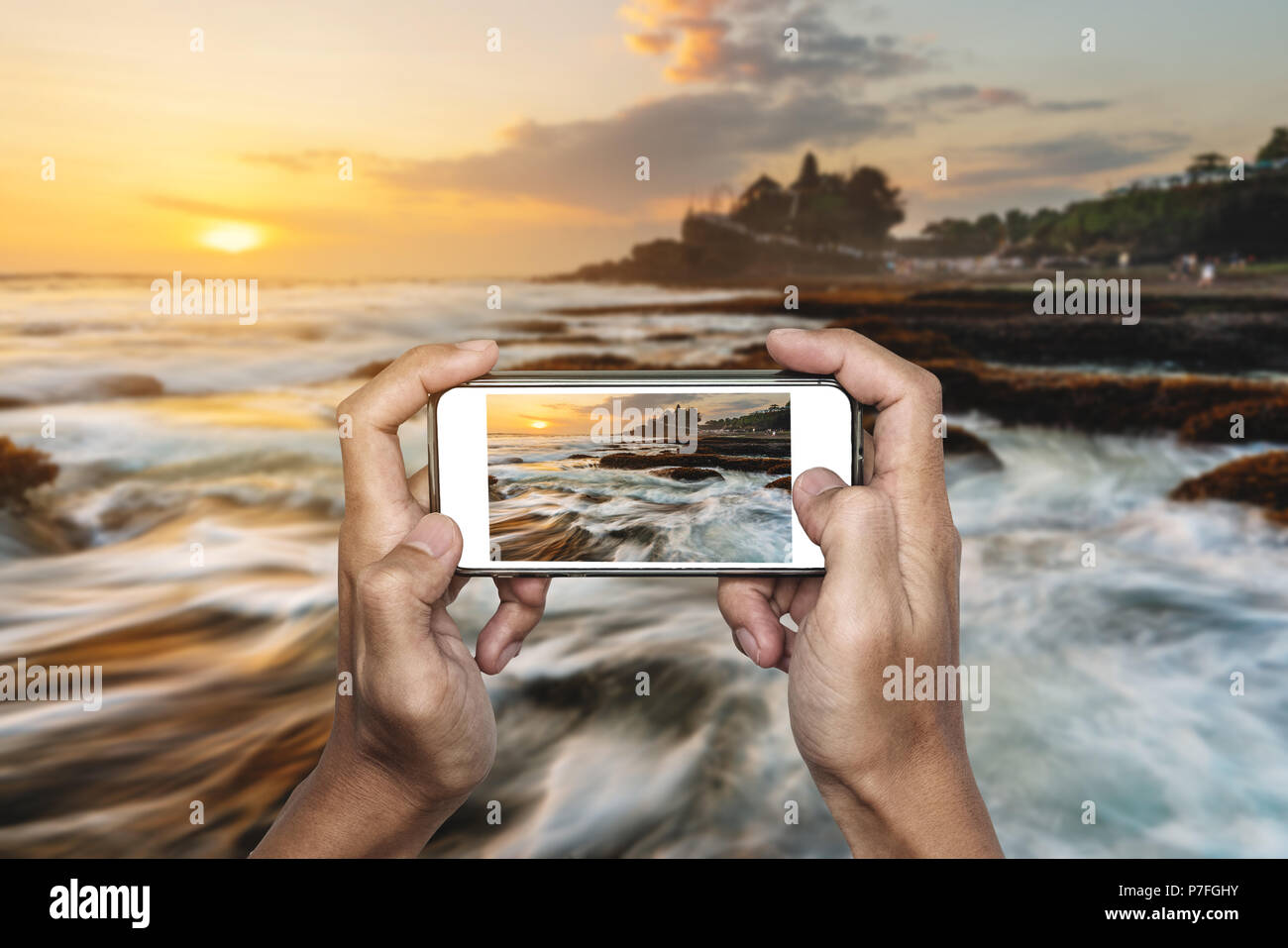 Travel Asia, hand taking photo of Tanah Lot temple in Bali, by mobile smart phone Stock Photo
