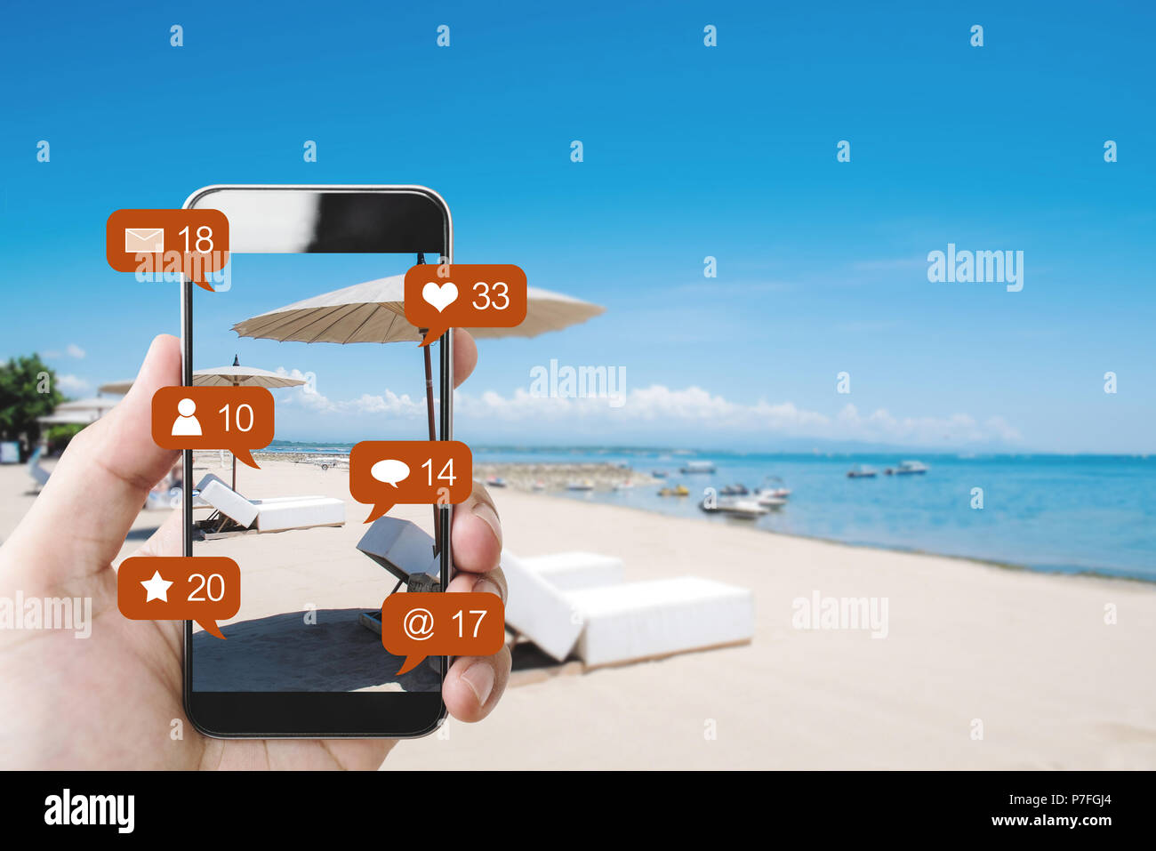 Hand mobile smart phone at the beach in summer, and social media with social network notification icons Stock Photo