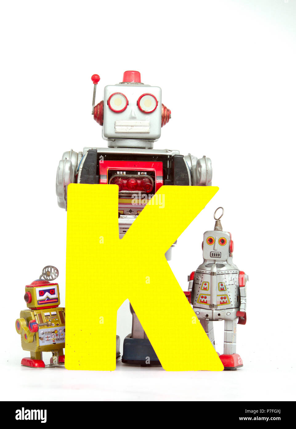 capital letter  K held by vintage robot toys Stock Photo