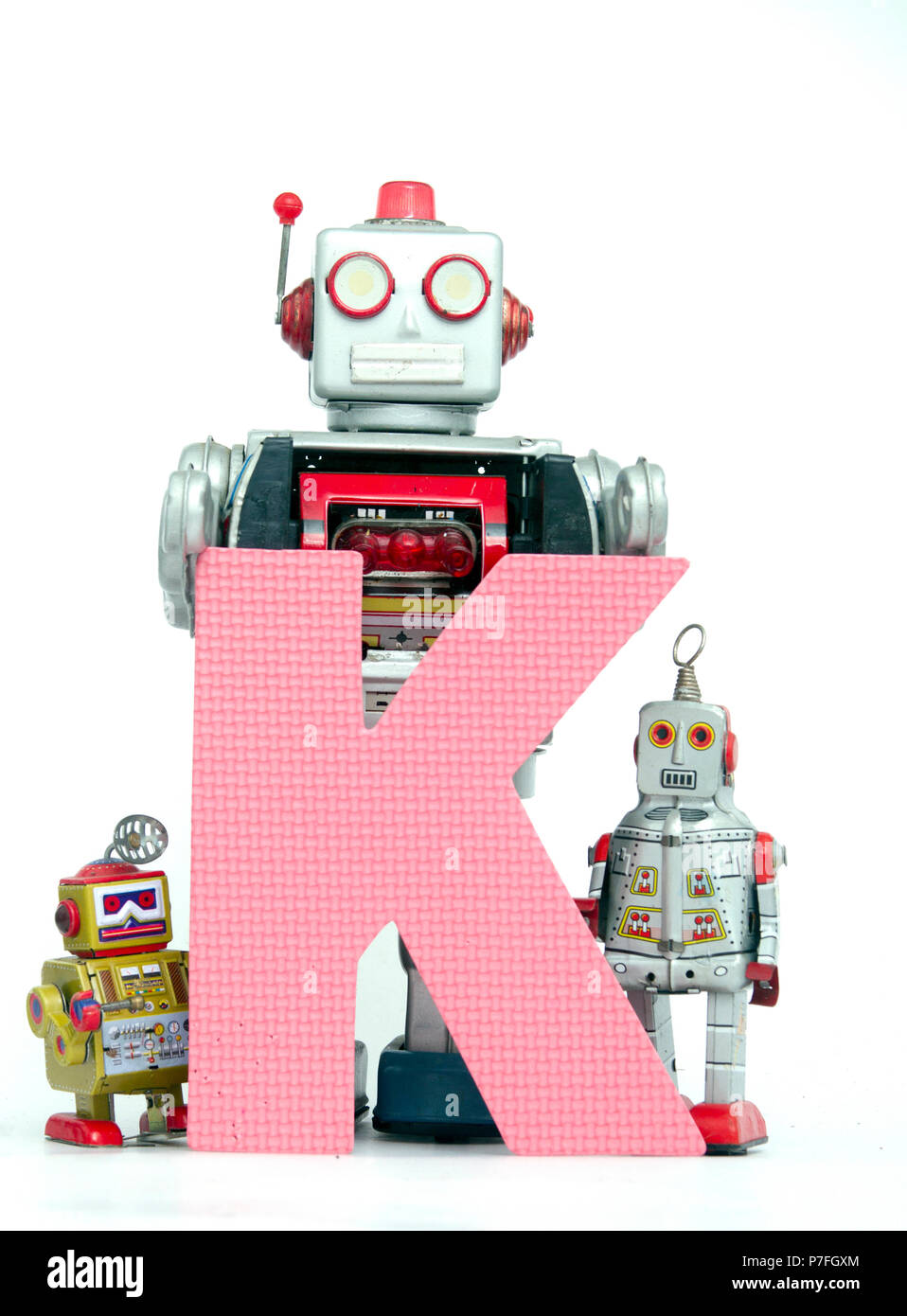 capital letter K  held by vintage robot toys Stock Photo
