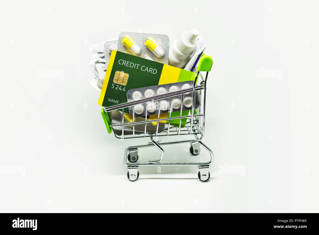 Many medicines and making purchases, Paying with a credit card. Basket of pills ointments and other medicines isolated on white background. increasing Stock Photo