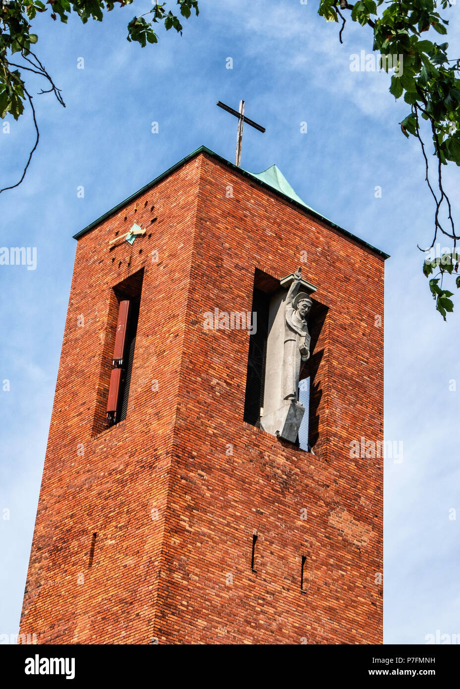 Berlin-Dahlem.dorf. Saint Bernard Catholic Church. Brick Building exterior & facade with bronze statue of St. Bernard of Clairvaux in recess Stock Photo