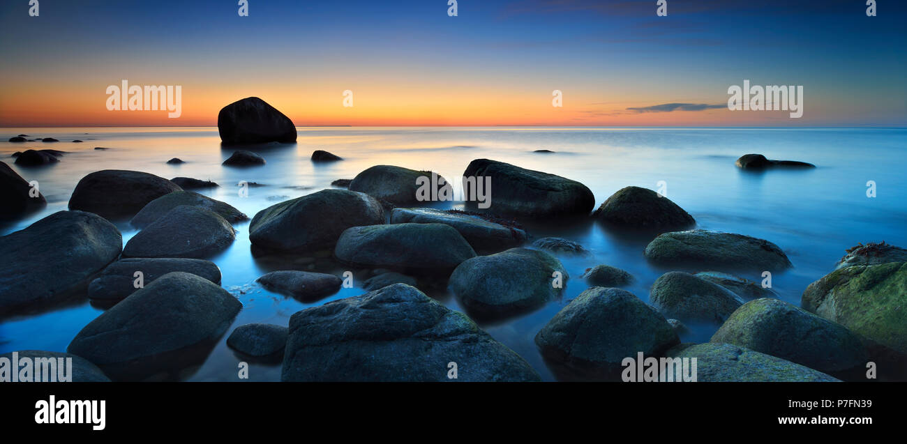 Sunset at the Baltic Sea, boulders on the shore, behind the Schwanenstein, Lohme, Jasmund National Park, Island of Rügen Stock Photo