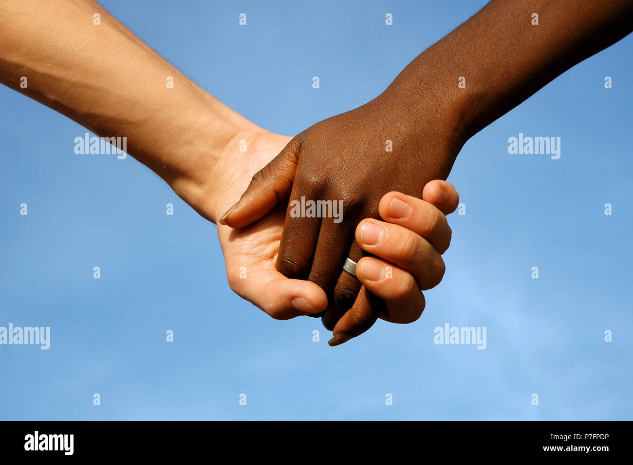 Dark-skinned and fair-skinned hand, hold hands, Hand in Hand, Friendship Stock Photo