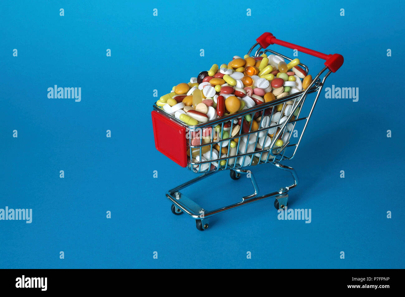 Shopping cart filled with coloured pills, symbol picture for addiction