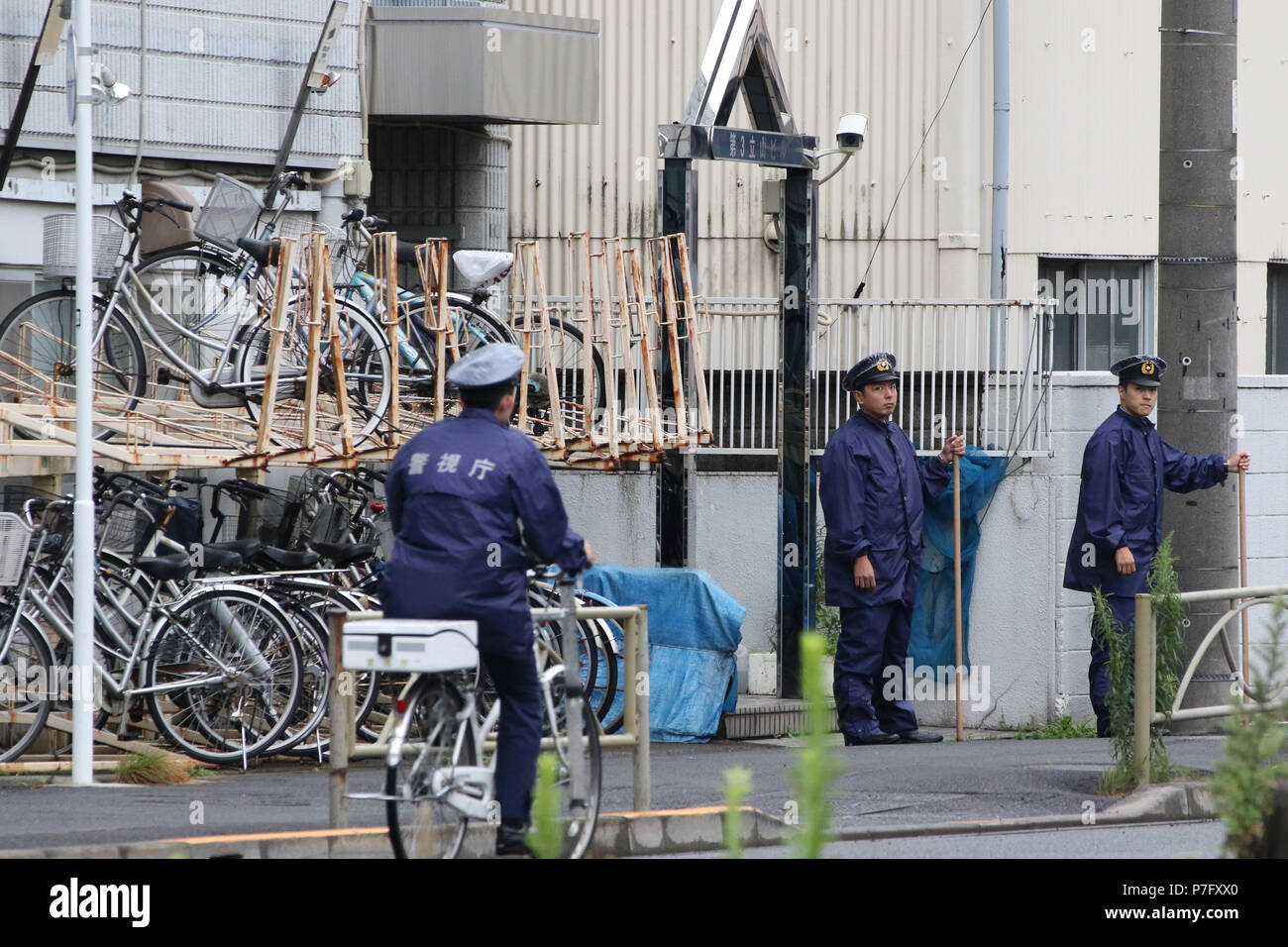 Tokyo, Japan. 6th July, 2018. Police officers stand at the entrance of a facility of a cult group Aleph in Tokyo on Friday, July 6, 2018. Aleph is a succession group of the doomsday cult AUM Shinrikyowhich which killed 29 people by Sarin gas attack at Tokyo subway in 1994. AUM guru Shoko Asahara was excuted at the Tokyo detention center for numerious crimes on July 6. Credit: Yoshio Tsunoda/AFLO/Alamy Live News Stock Photo