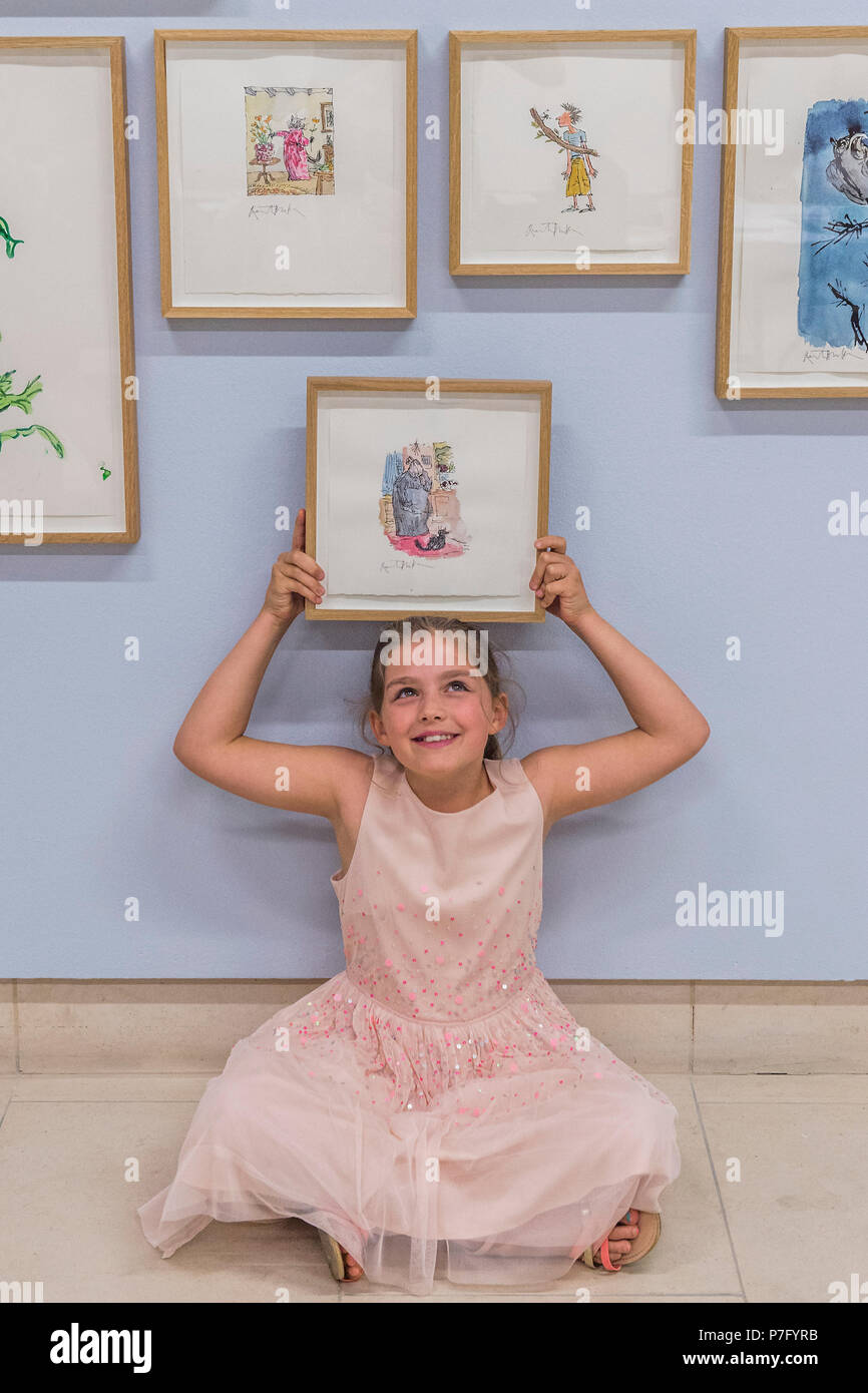 London, UK. 6th July, 2018. Eliza Manson, aged 9 and 3/4, enjoys posing with the works. Quentin Blake: A Retrospective; Forty Years of Alternative Versions, a series of illustrations, offered directly from the personal collection of one of Britain's best-loved illustrators, at Christies King Street. The works will be on view and open to the public from 7 to 10 July at Christie’s London with estimates range from £200 to £10,000. Credit: Guy Bell/Alamy Live News Stock Photo