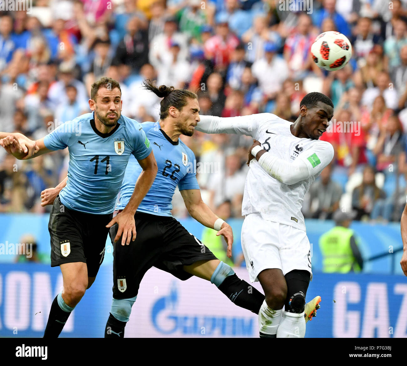 Nizhny Novgorod, Russia. 6th July, 2018. Martin Caceres (C) of Uruguay competes for a header with Paul Pogba (R) of France during the 2018 FIFA World Cup quarter-final match between Uruguay and France in Nizhny Novgorod, Russia, July 6, 2018. Credit: Liu Dawei/Xinhua/Alamy Live News Stock Photo