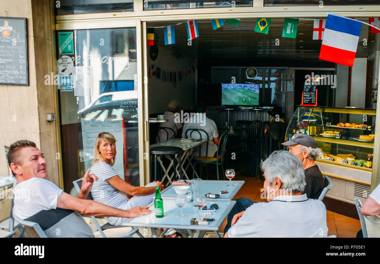 Juan les Pins, France - July 6th, 2018: Group of friends sitting outdoors at a cafe in Juan les Pins, Cote d'Azur, France watching France x Uruguay, the Quarter-Final Match in Russia 2018 World Cup football tournament Credit: Alexandre Rotenberg/Alamy Live News Stock Photo
