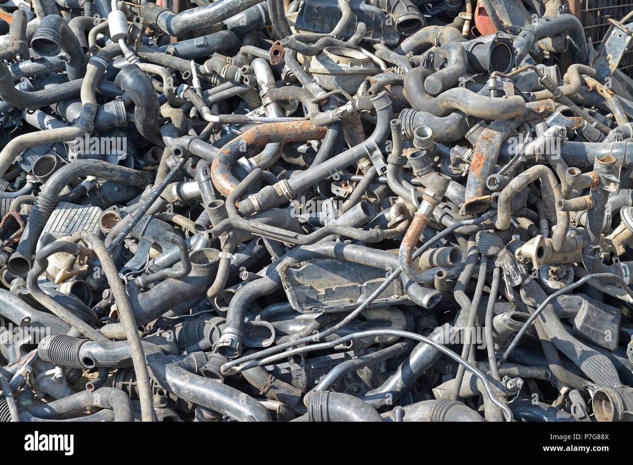 a heap of car engine pipes in a junkyard Stock Photo Alamy