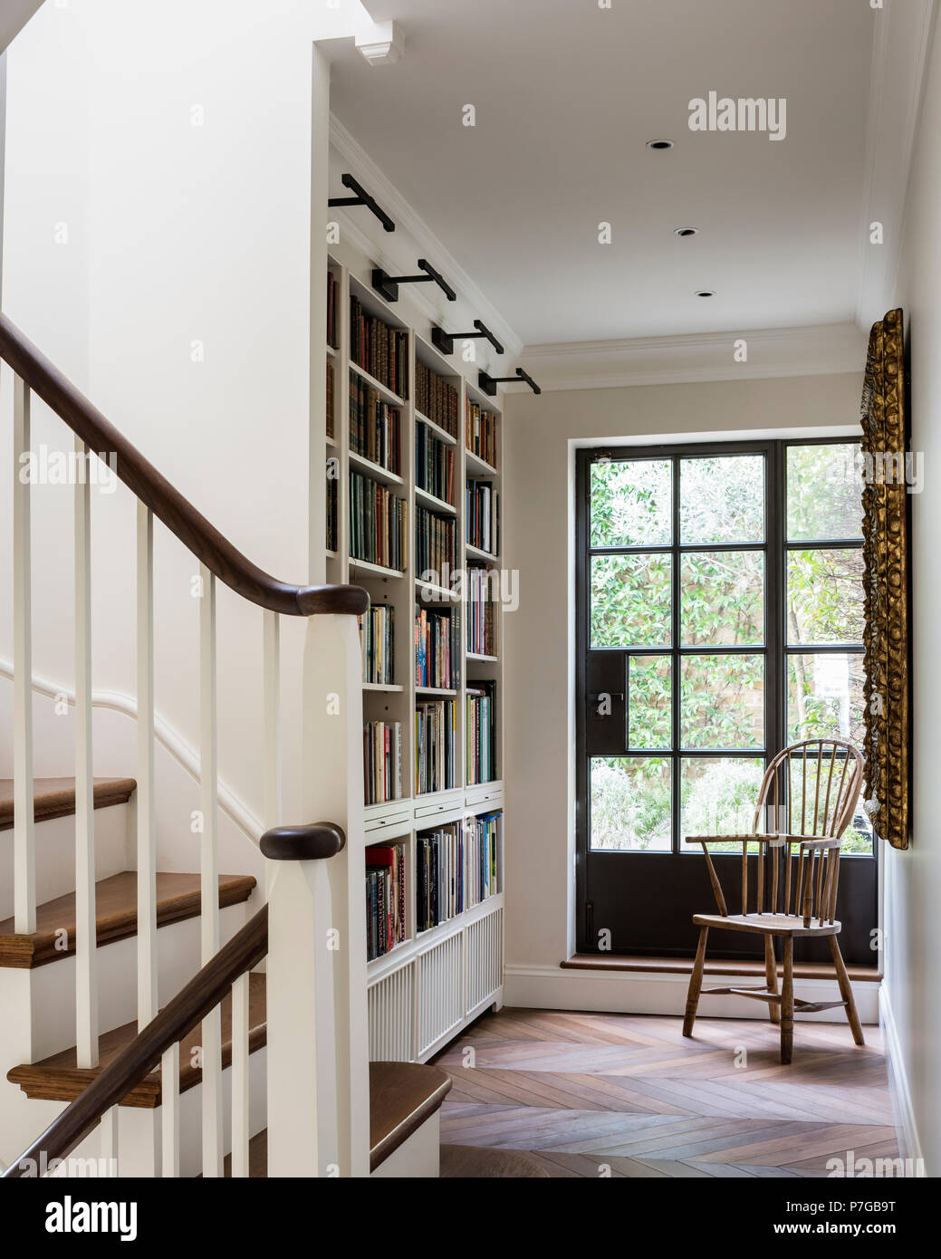 Bookshelf and chair in front of glass door Stock Photo Alamy