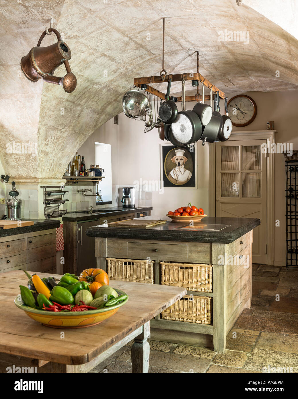Assorted pans hang on rack above kitchen island in 18th century chateaux,  St Remy de Provence Stock Photo - Alamy
