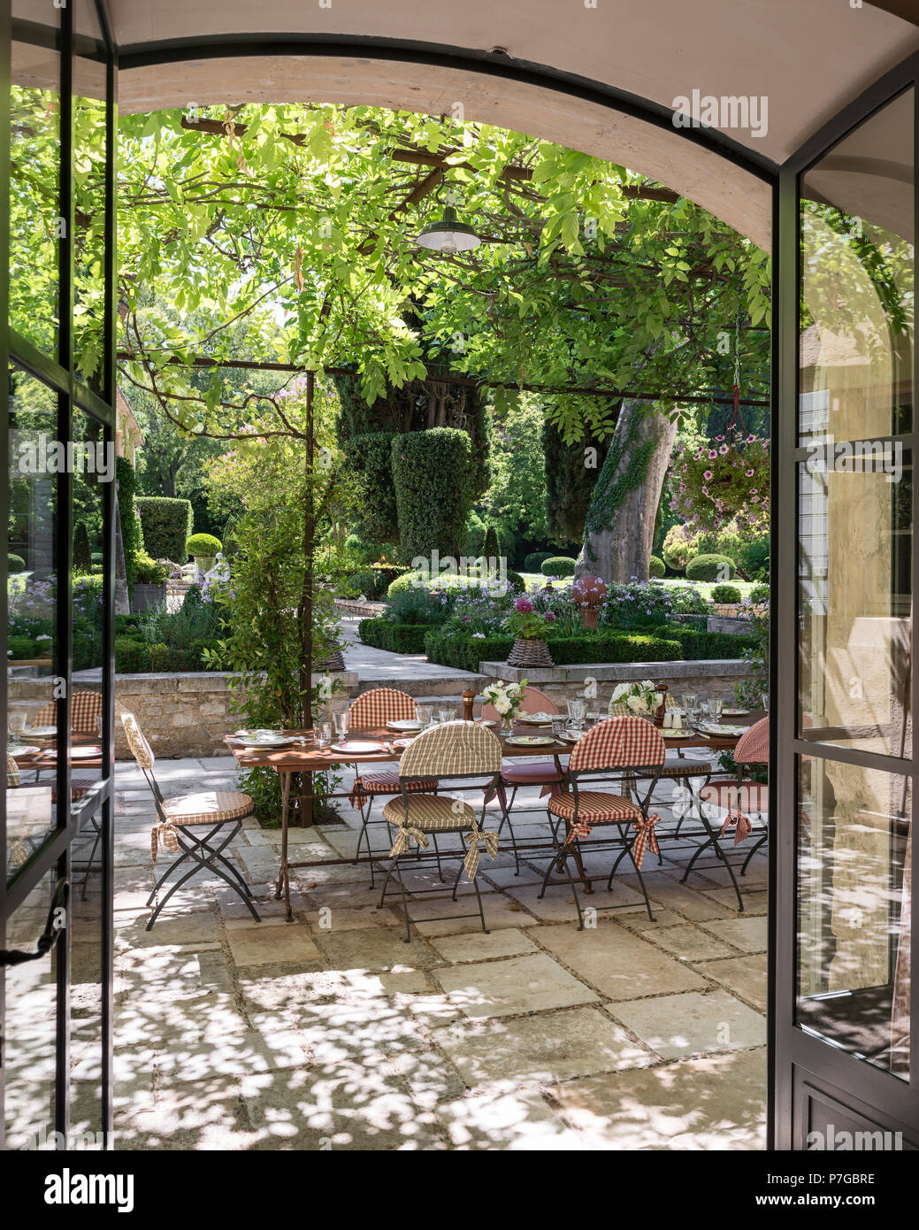 Table and chairs under pergola on terrace of 18th century chateaux, St