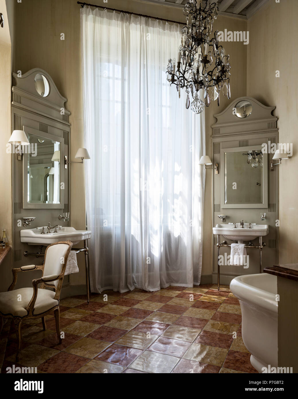 Chandelier with double basins and full length curtains in 18th century chateaux, St Remy de Provence Stock Photo