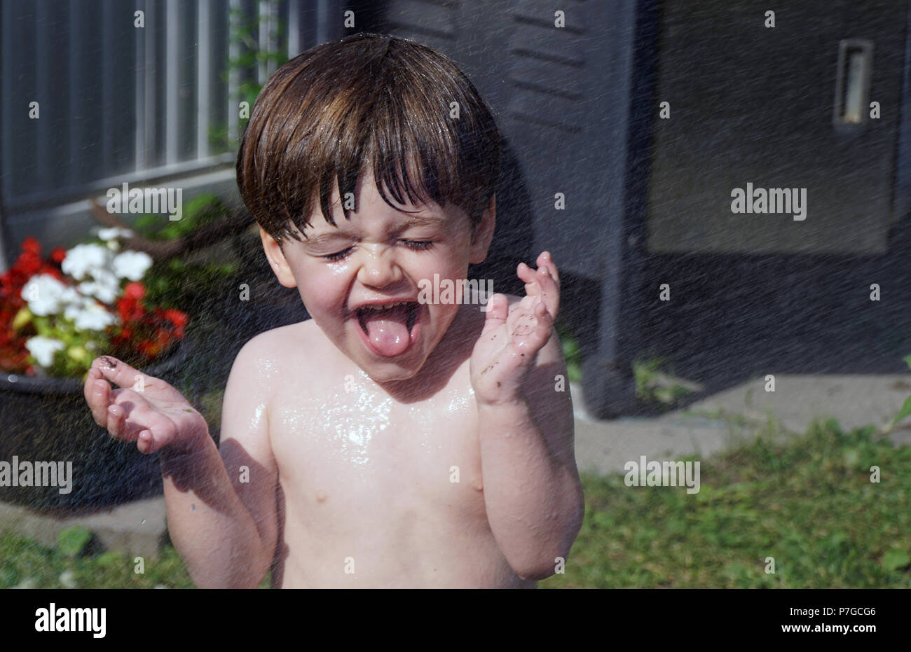 Montreal, Canada, July 2, 2018.Young three-old boy being sprayed with water during a heat wave.Credit Mario Beauregard/Alamy Live News Stock Photo