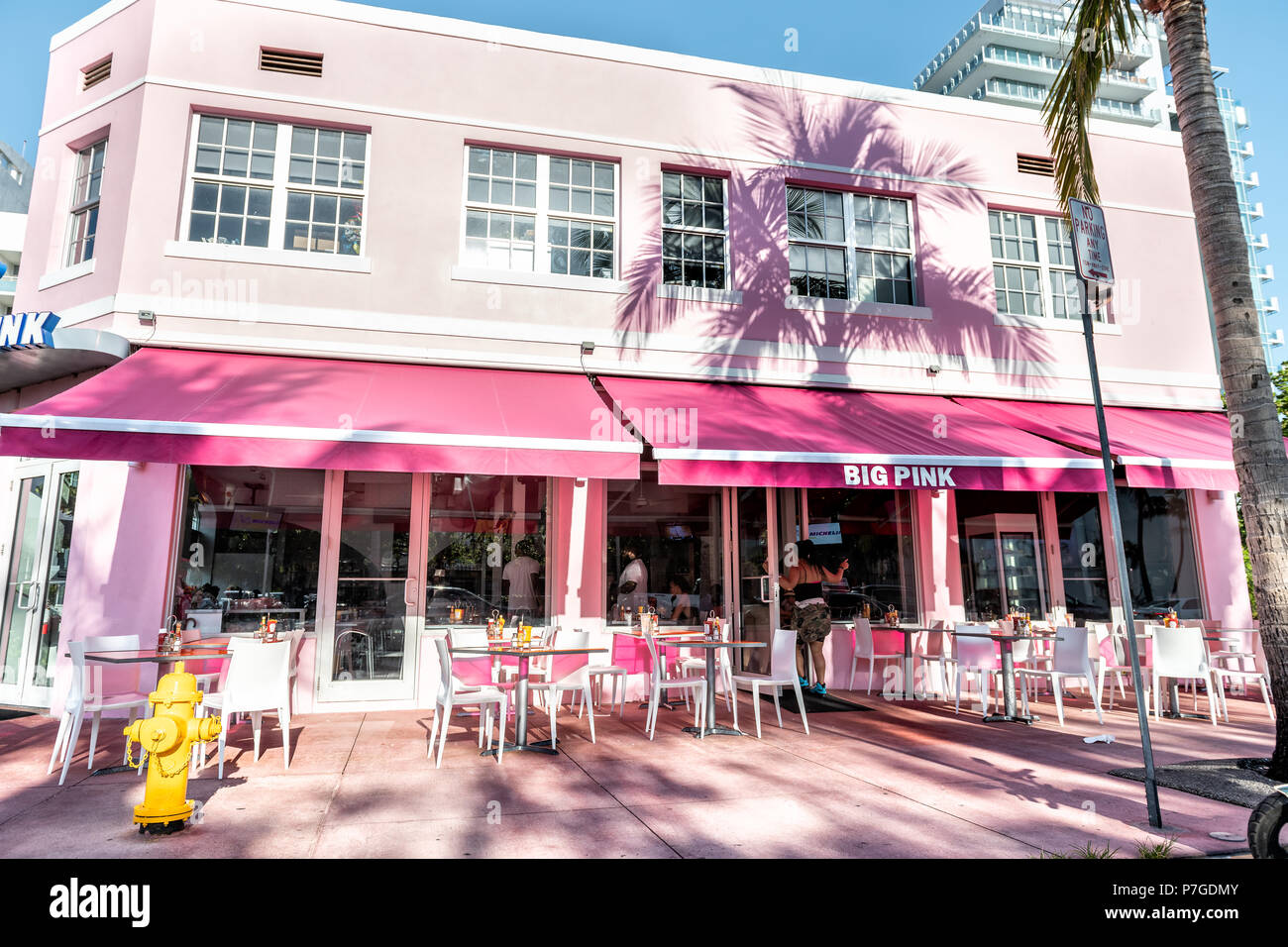 Miami Beach, USA - May 5, 2018: Big Pink diner, restaurant, cafe at Ocean Drive Art Deco district on sunny day with outside sitting empty area, tables Stock Photo
