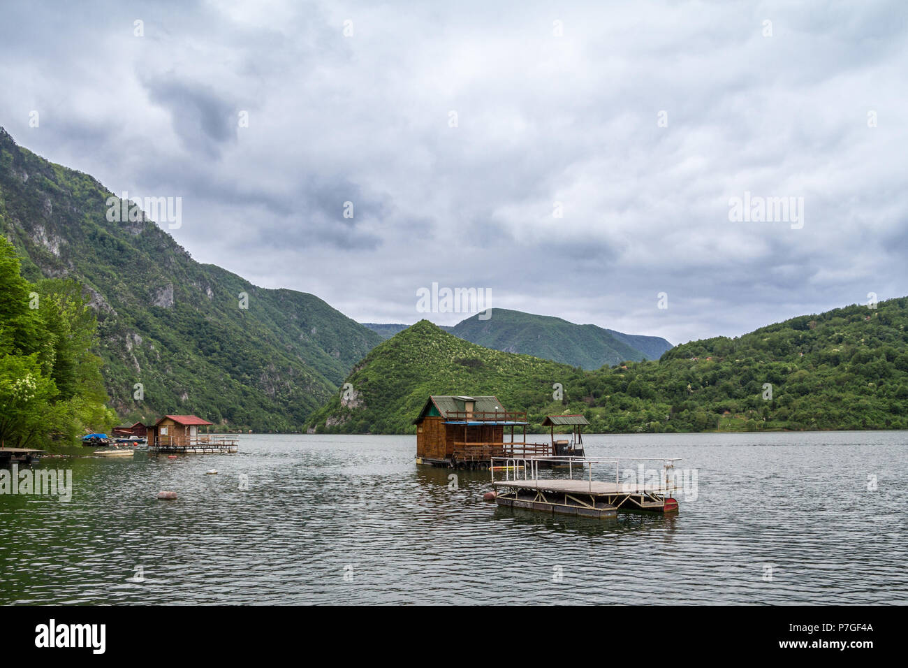 Fishemen floating houses on Perucac lake, on the Drina river, in Western Serbia, surrounded by a valley and narrow canyon and a forest made of pine tr Stock Photo