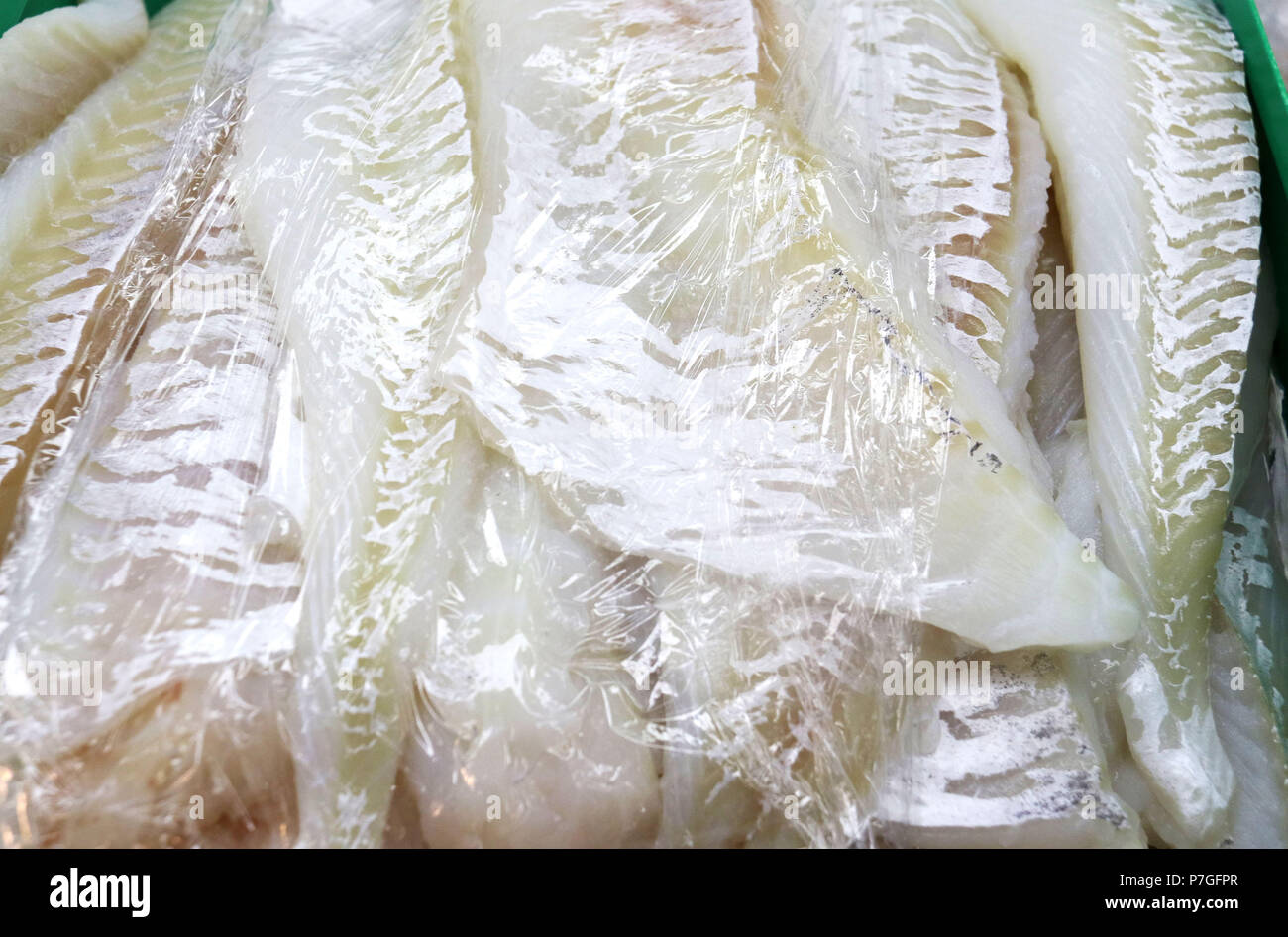 Wild cod fish fillets covered with cellophane wrap Stock Photo