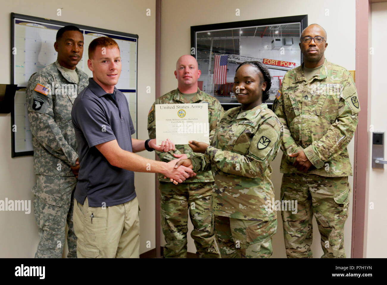 Pvt. 1st Class Shenequa Hector, Virgin Islands National Guard 661st Military Police Law and Order Detachment, receives her certificate from Staff Sgt. Patrick Sanders, Ft. Polk 91st Military Police Detachment, for completing a Mechanical Control Holds (MACH) and X26 series taser course as part of annual training at Ft. Polk, LA, June 26, 2018. This training reiterated and put to use the members of the 661st Military Police Law and Order Detachment military occupational specialty.  (U.S. Army National Guard photo by Army Sgt. Priscilla Desormeaux/Released) (Photograph cropped to highlight subje Stock Photo