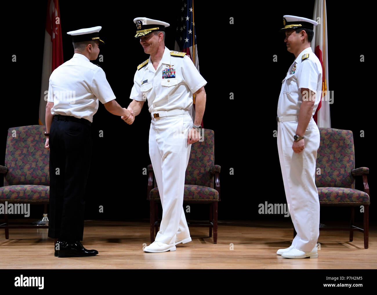 180628-N-RM440-1074 MANAMA, Bahrain (June 28, 2018) Vice Adm. Scott Stearney, middle, commander of U.S. Naval Forces Central Command, U.S. 5th Fleet and Combined Maritime Forces,  shakes the hand of Republic of Singapore Navy Rear Adm. Saw Shi Tat, oncoming commander of Combined Task Force (CTF) 151, left, during the task force's change of command ceremony on Naval Support Activity Bahrain. CTF 151's mission is to disrupt piracy at sea and to engage with regional and other partners to build capacity and improve relevant capabilities in order to protect global maritime commerce and secure freed Stock Photo