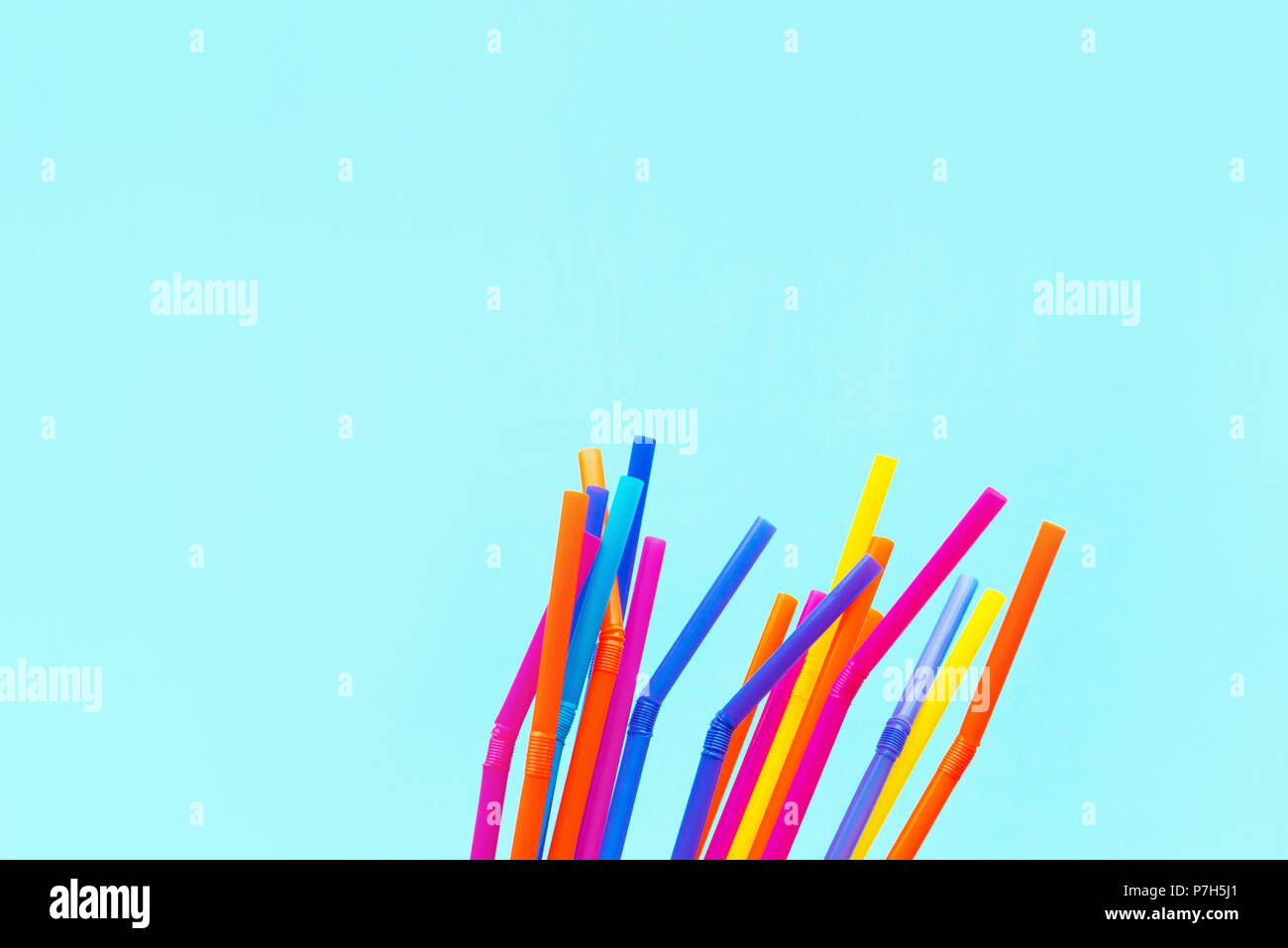 Summer season background, colorful drinking straws on blue backdrop with copy space Stock Photo
