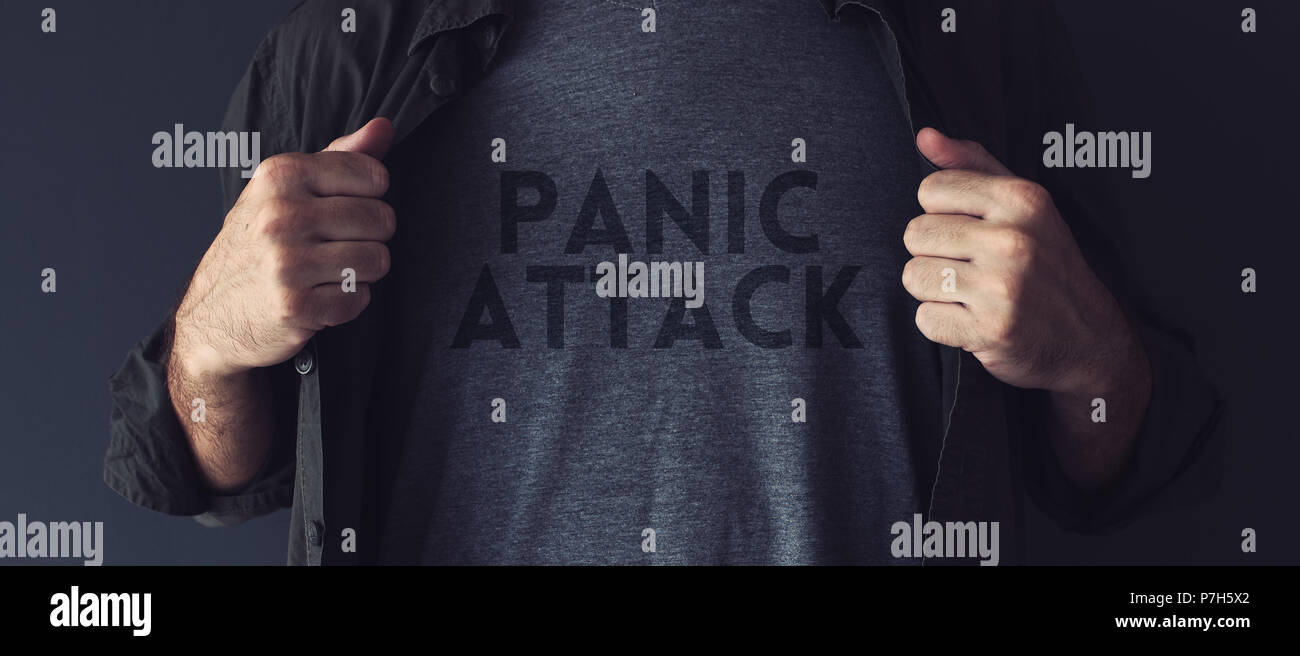Panic attack concept, guy stretching shirt to reveal the title imprint on his chest Stock Photo