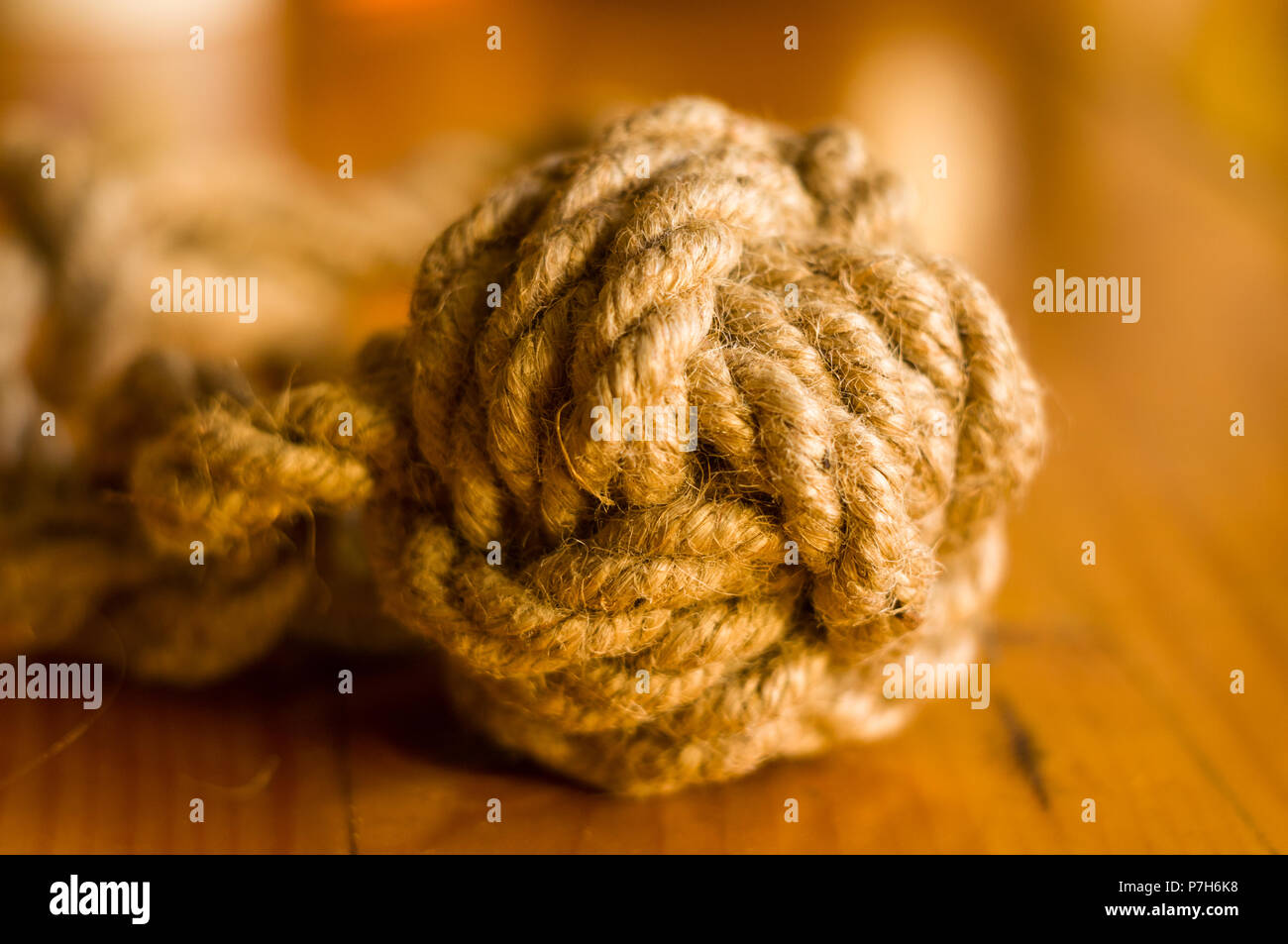 fender marine knot of thick brown rope on a wooden background