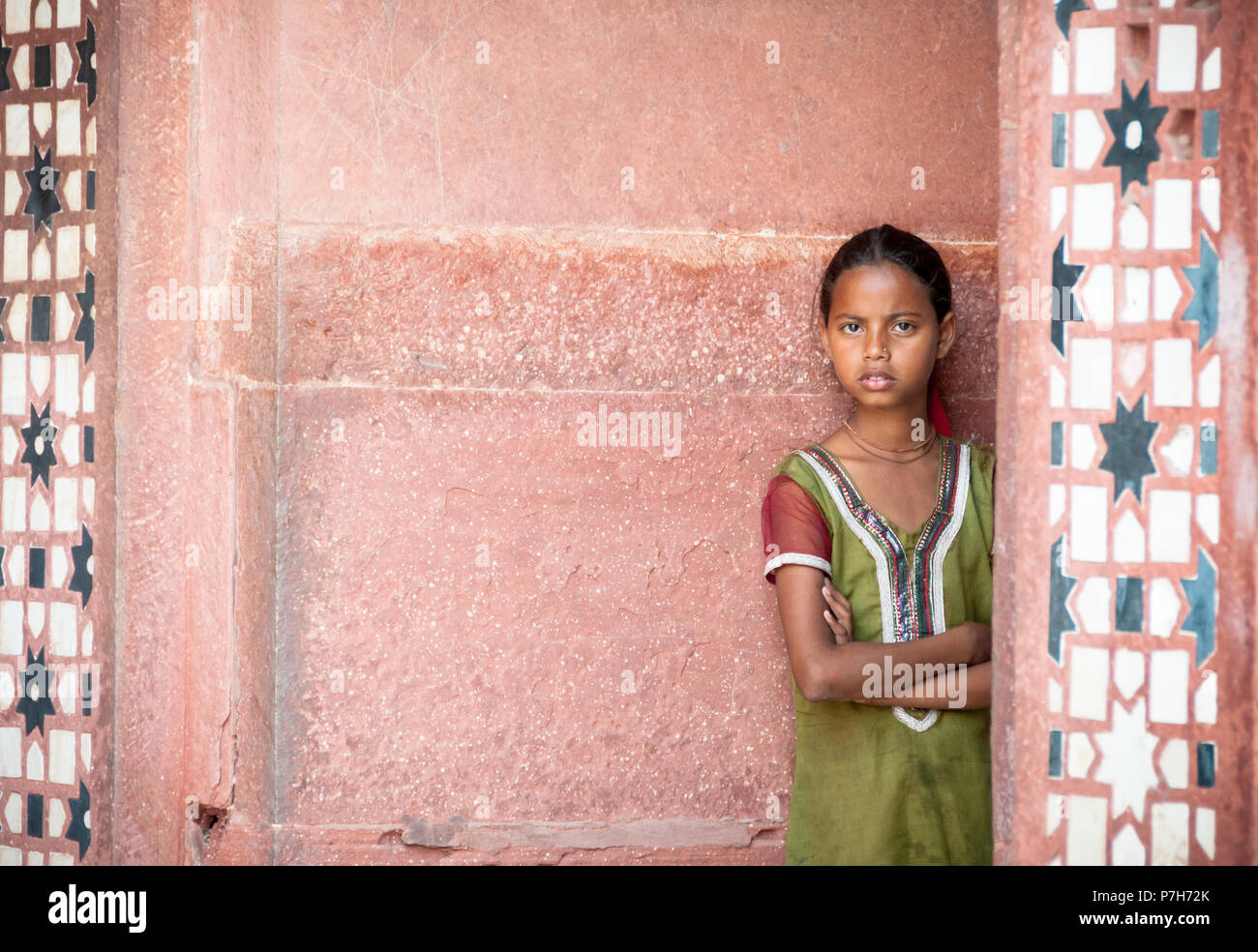 Beautiful young Indian girl in traditional green dress leaning against temple wall Agra Uttar Pradesh Stock Photo