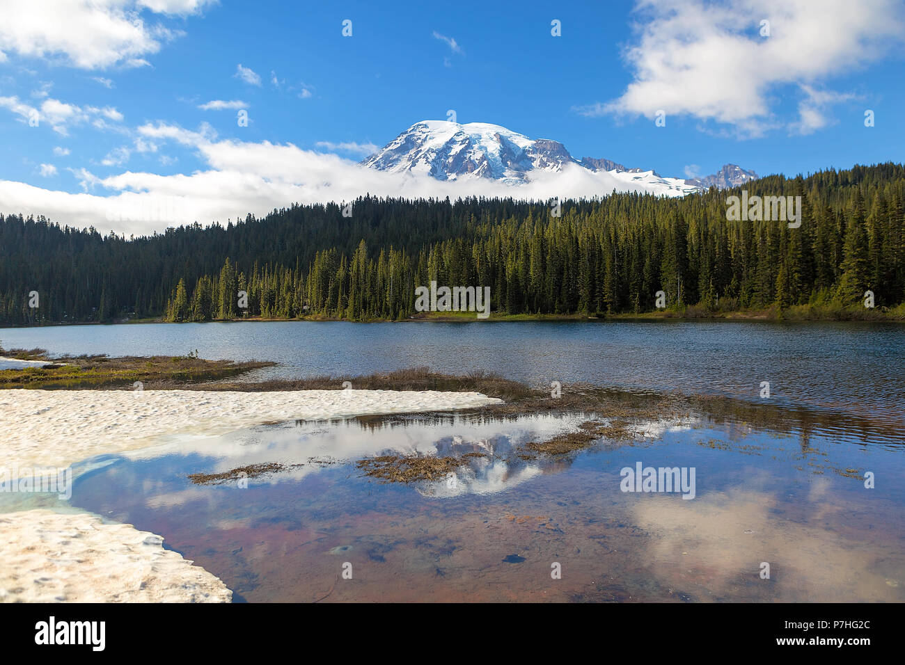 Reflection Lakes in Mount Rainier National Park in Washington State with snow clouds and blue sky Stock Photo