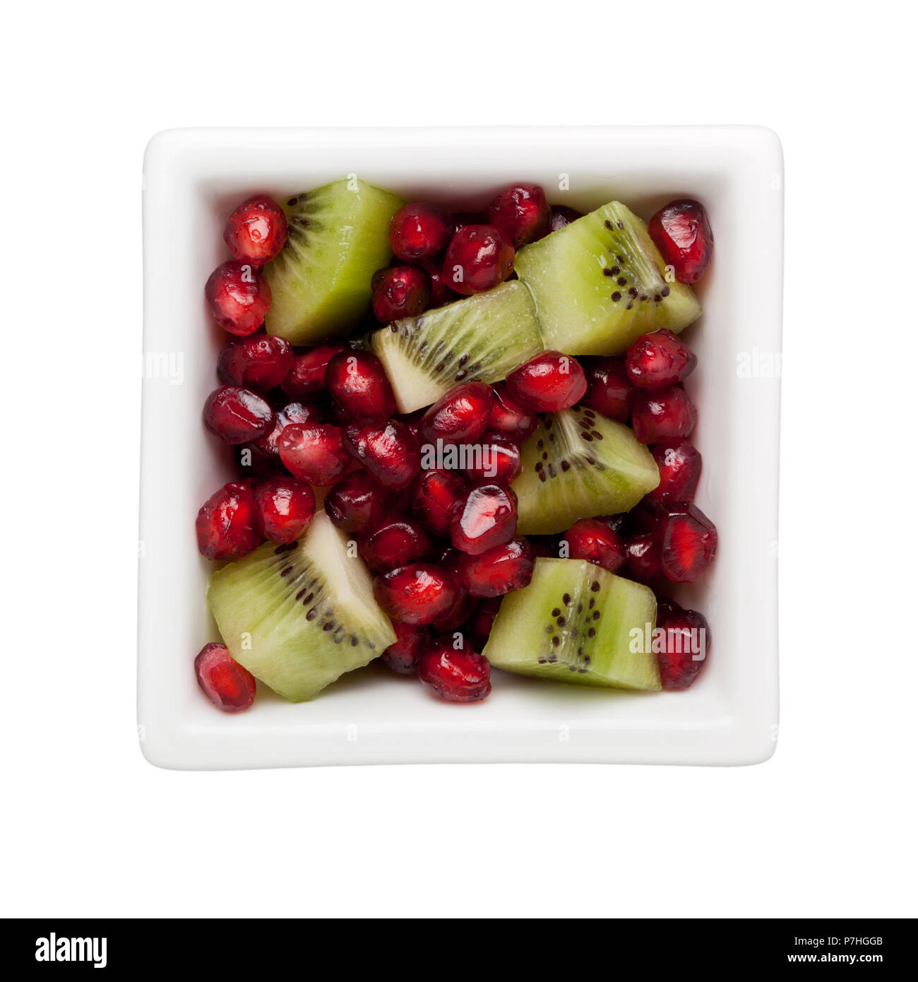 Pomegranate arils and diced kiwifruit in a square bowl isolated on white background Stock Photo