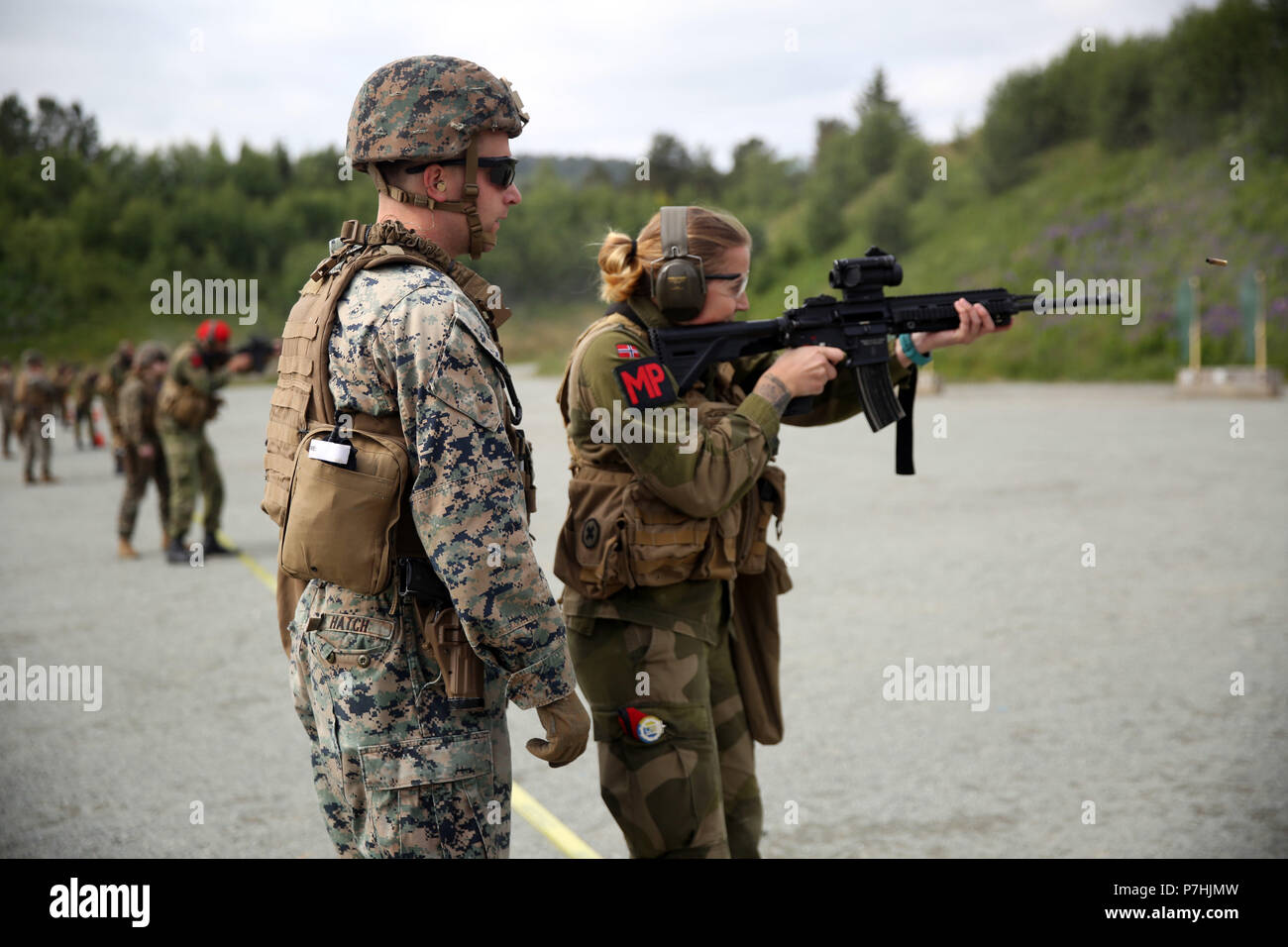 A U.S. Marine with Marine Rotational Force-Europe 18.1 coaches a Norwegian military policeman during a weapon transition range at Leksdal Skytefelt Training Complex, Norway, June 27, 2018. The multinational training allowed the service members to cross-train with American and Norwegian weapon systems including assault rifles, shotguns, and pistols. The Marines and Norwegian soldiers practiced firing from behind barricades and transitioning between weapon systems. (U.S. Marine Corps photo by Cpl. Gloria Lepko/Released) Stock Photo