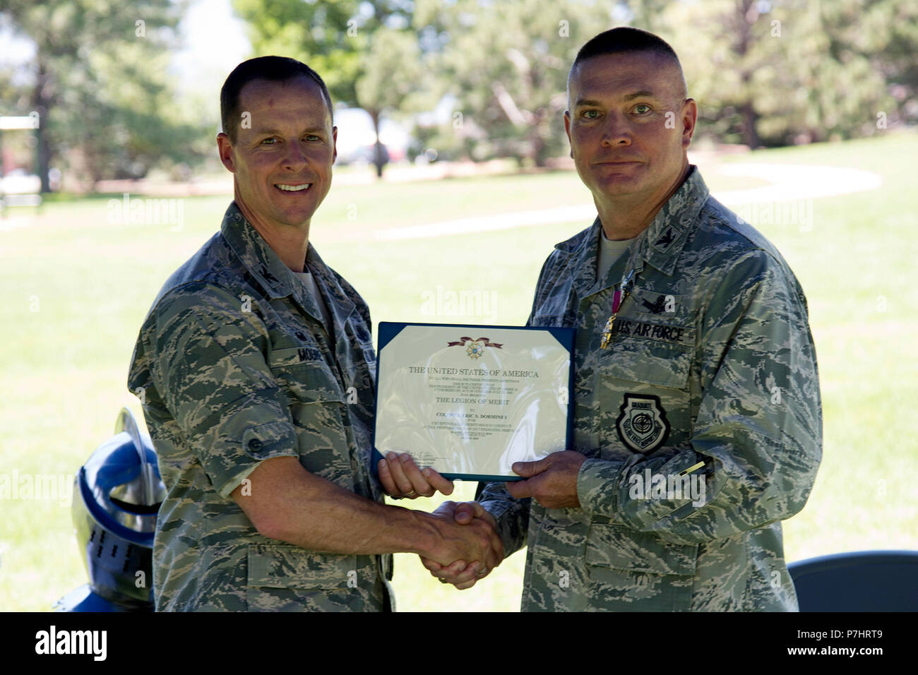 PETERSON AIR FORCE BASE, Colo. – Col. Todd Moore, 21st Space Wing commander, presents the Legion of Merit to Col. Eric Dorminey, 21st Space Wing outgoing vice commander, at a going away barbecue at Capt. Lyon Memorial Park at Peterson Air Force Base, Colorado, July 2, 2018. Dorminey became 21 SW vice commander in April, 2015, and spent nearly 39 months in the position. (U.S. Air Force photo by Robb Lingley) Stock Photo