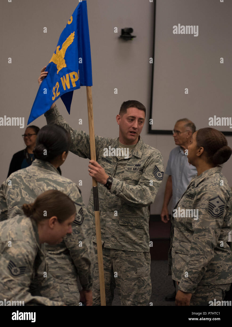 Tech. Sgt. Kieth Kuzniar, 32nd Weapons Squadron superintendent, shows off the new squadron guidon to Master Sgt. Brandi Love, U.S. Air Force Weapons School first sergeant, during an assumption of command ceremony at Nellis Air Force Base, Nevada, June 28, 2018. The 32nd WPS will focus on teaching Cyber Warfare Operations. (U.S. Air Force photo by Airman 1st Class Andrew D. Sarver) Stock Photo