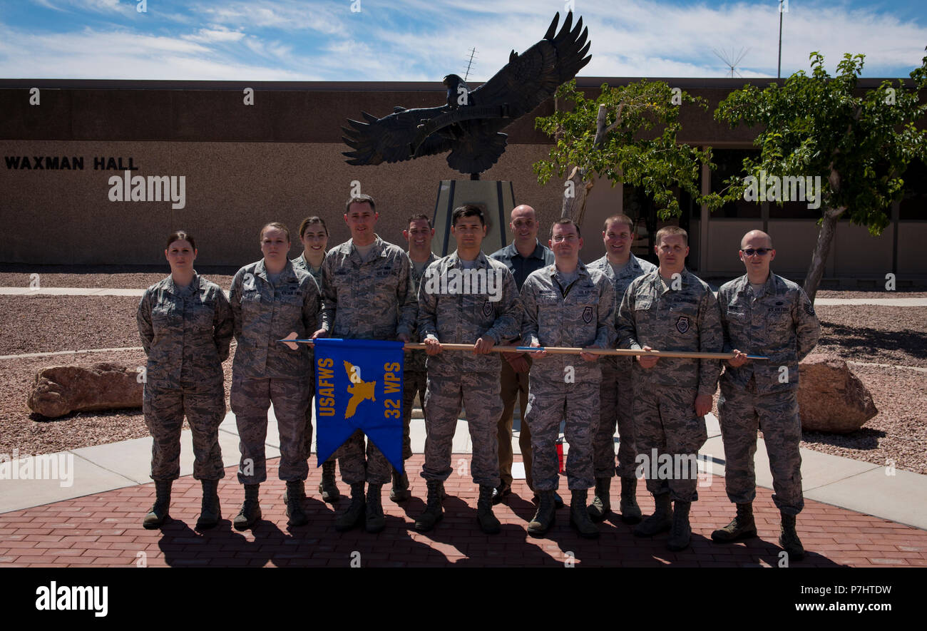 Members assigned to the 32nd Weapons Squadron stand in front of the U.S. Air Force Weapons