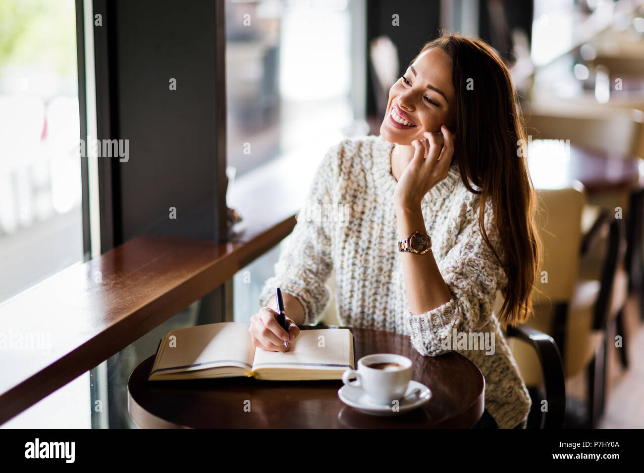 Portrait of happy young woman in cafe Stock Photo - Alamy