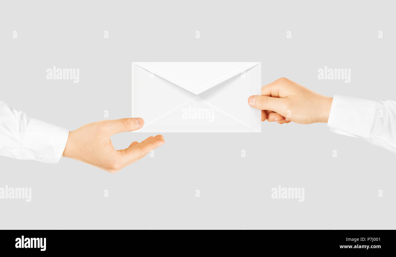 White blank envelope giving hand. Message send presentation. Person taking clear envelope email mockup. Post shipping delivering. Sharing mail message. Sending message men. Stock Photo