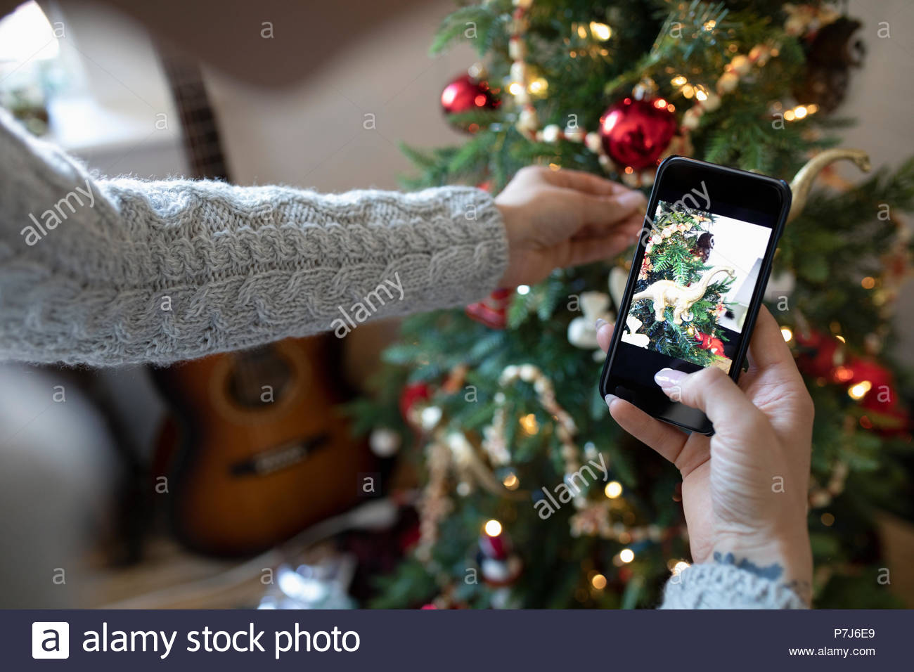 Young Woman With Camera Phone Decorating Apartment Christmas Tree Young Woman With Camera Phone Decorating Apartment Christmas Tree