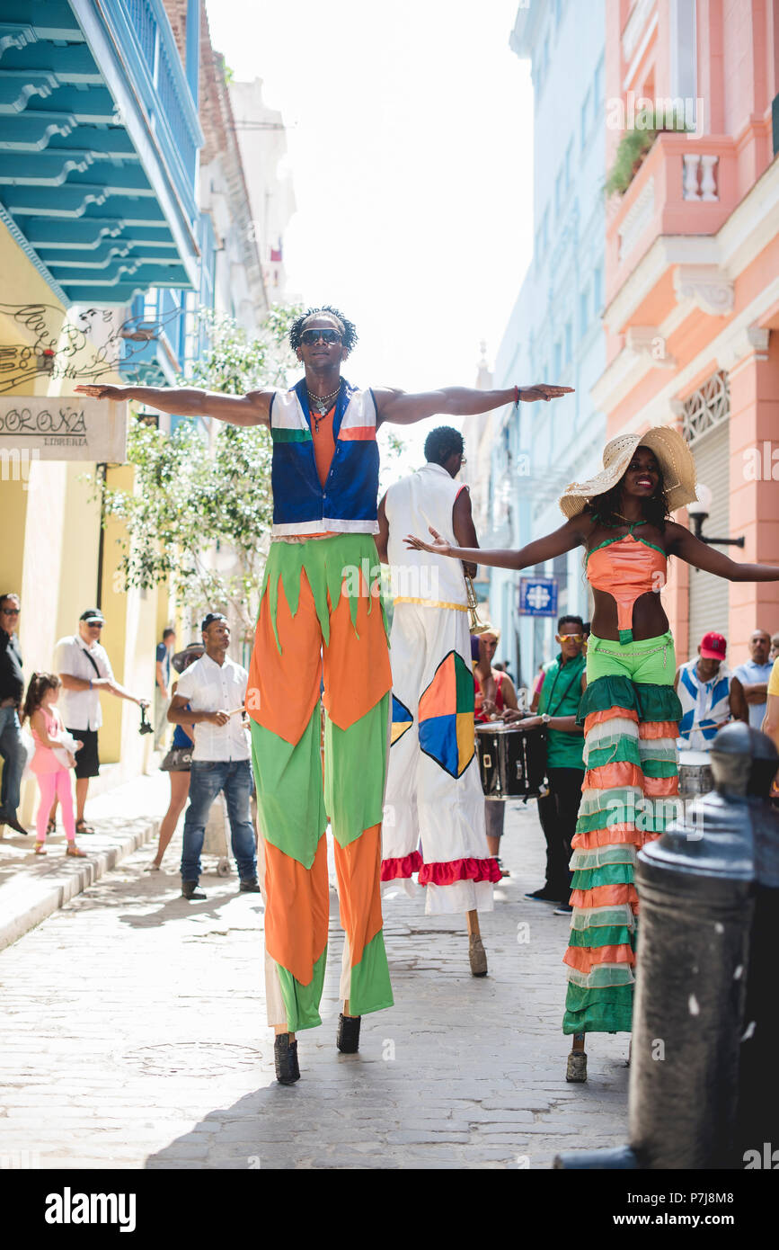 A street performance with stilt dancers and musicians in historic ...