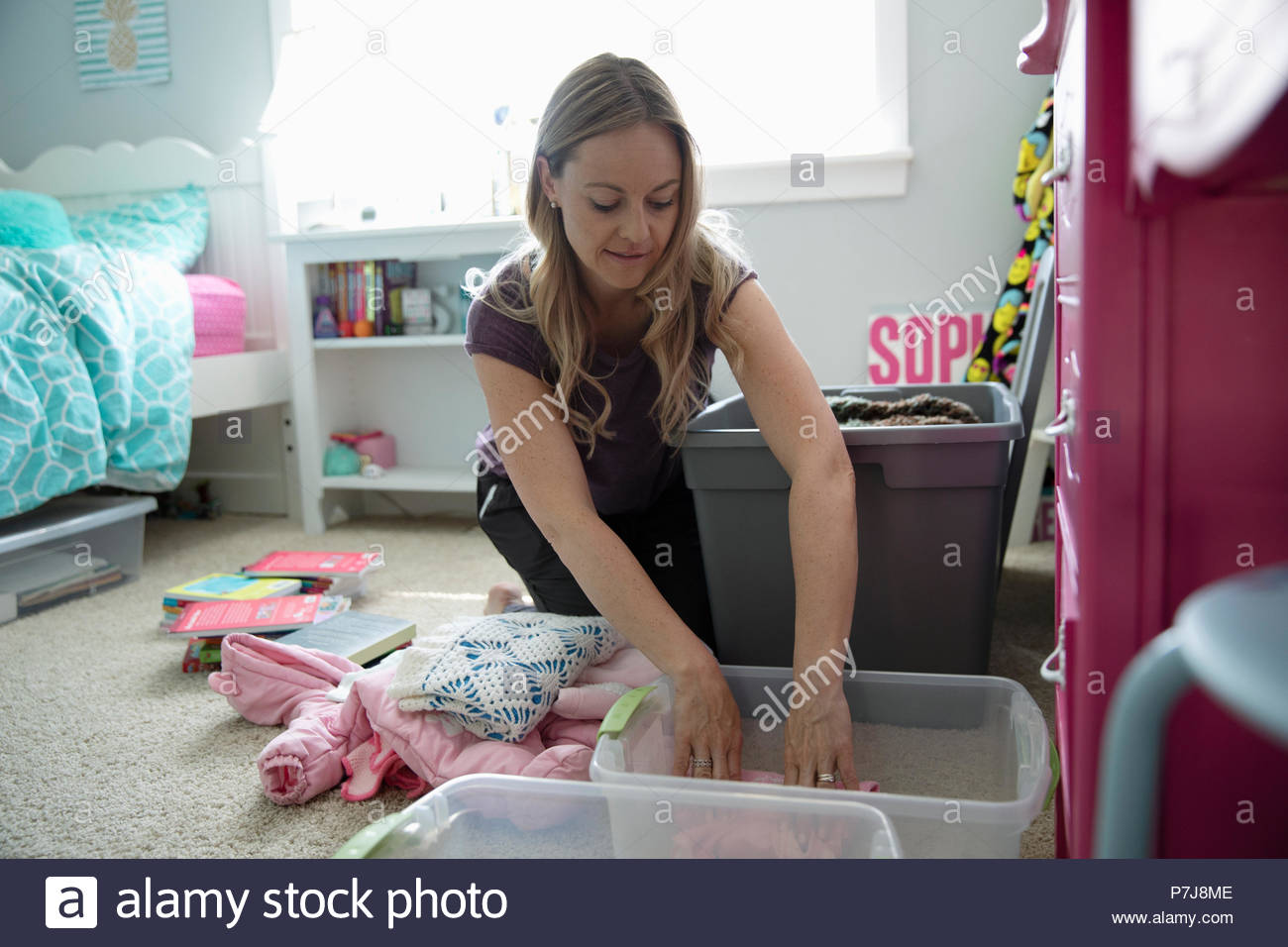 Mother organizing daughters bedroom Stock Photo