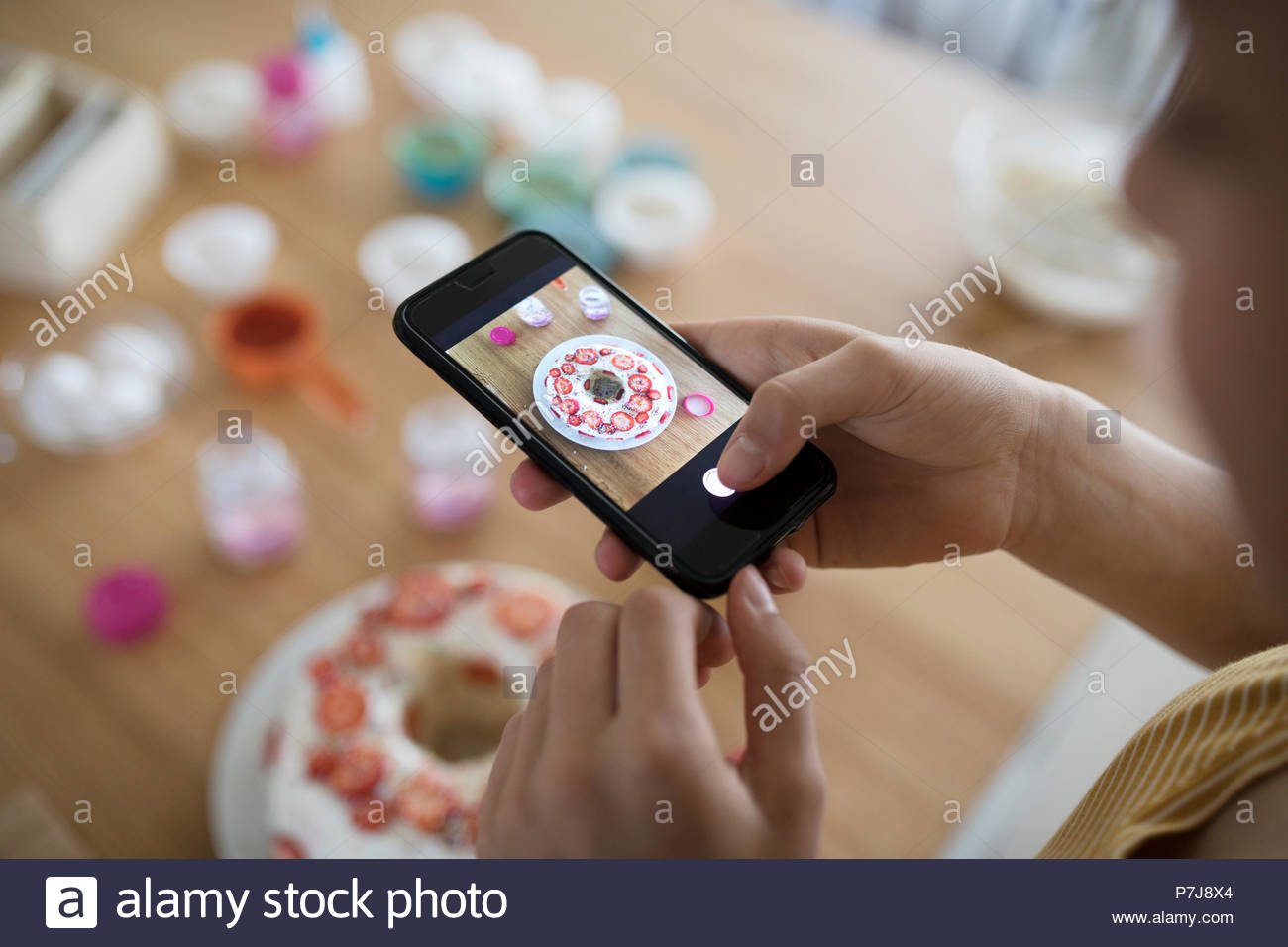 Girl with camera phone photographing cake Stock Photo