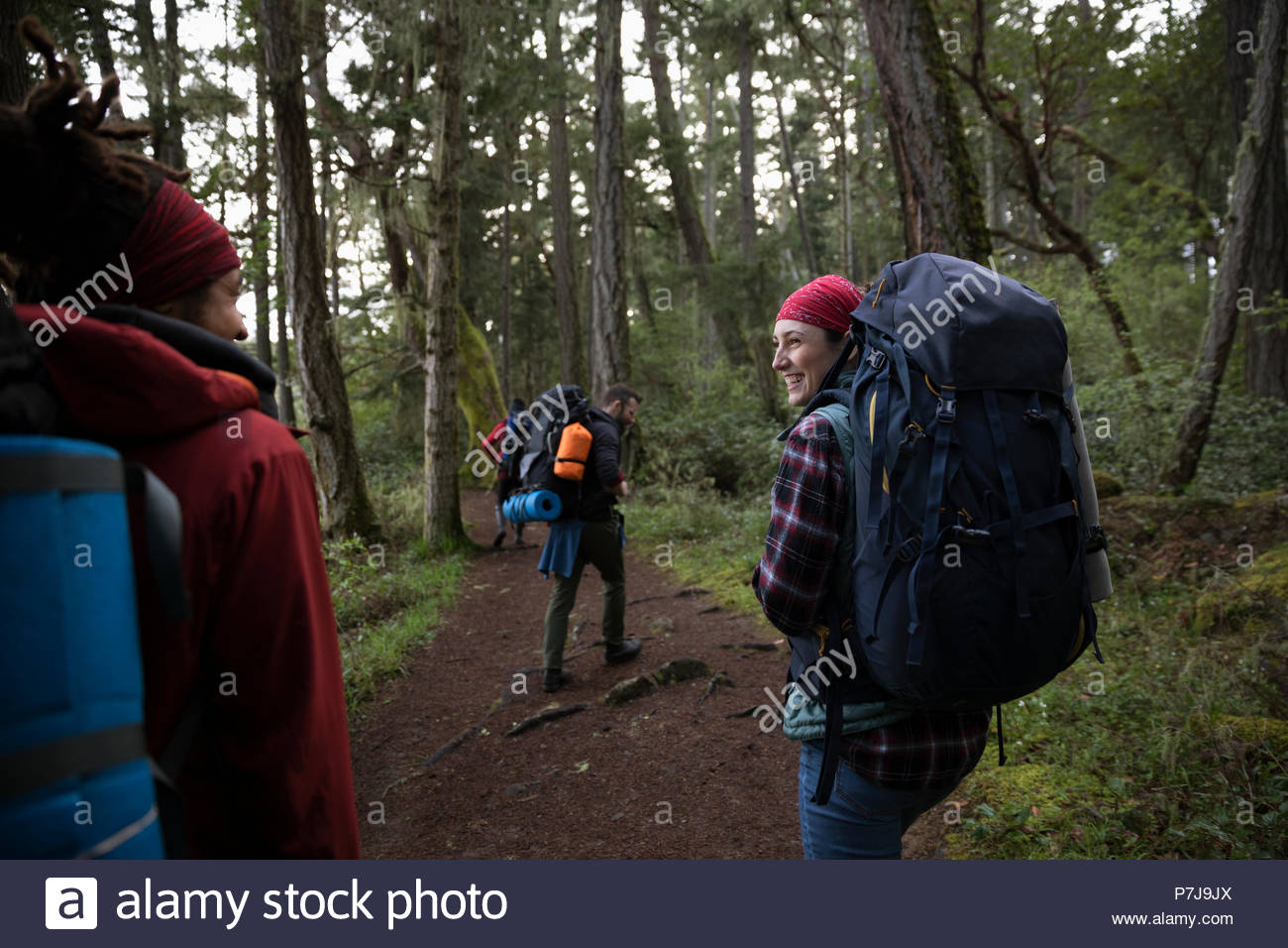 Friends backpacking in woods Stock Photo