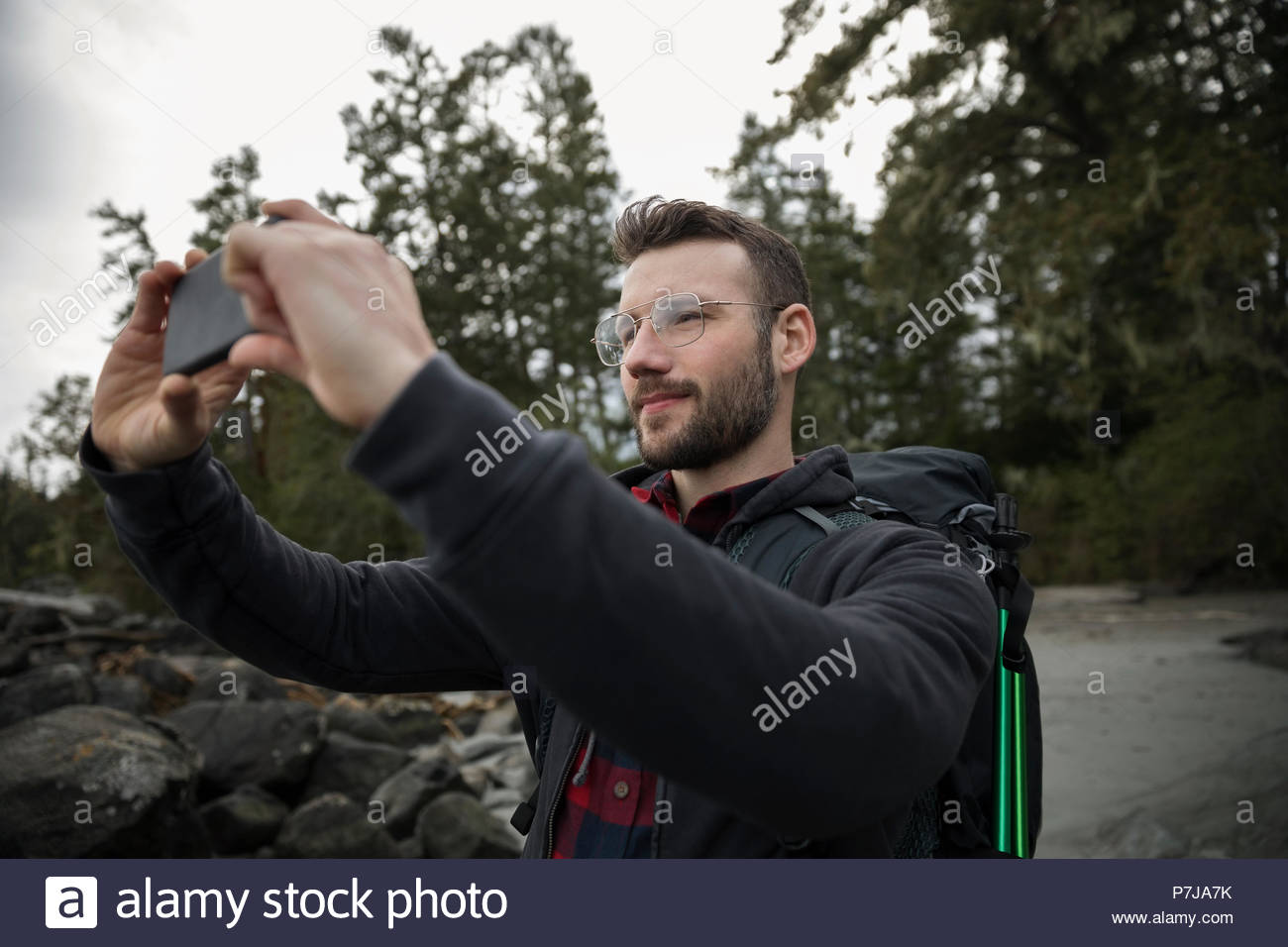 Male backpacker using camera phone Stock Photo