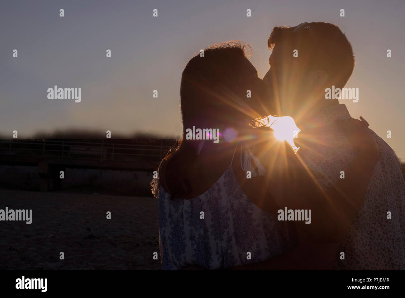 Silhouette of a couple kissing at sunset Stock Photo - Alamy